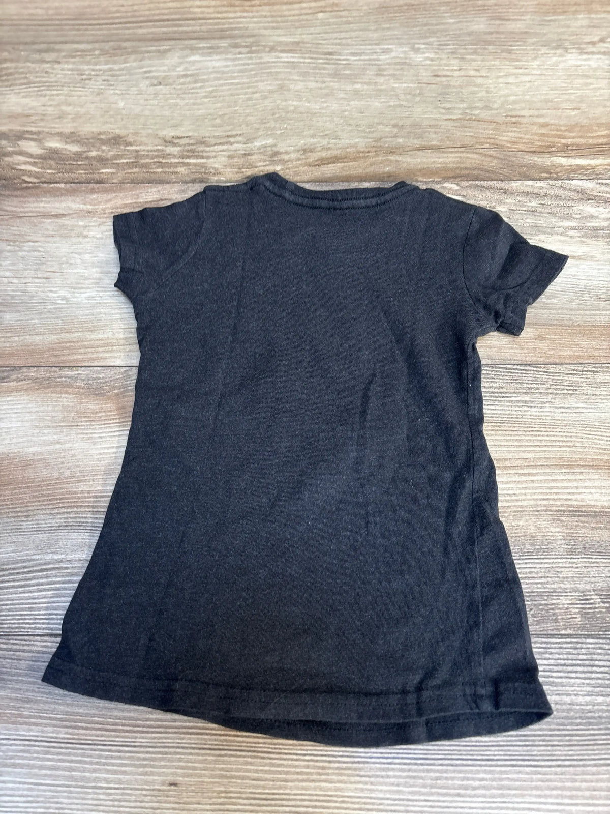 Back view of Instant Message Wicked Glenda toddler t-shirt, grey 2T, showing plain back and short sleeves on wood background