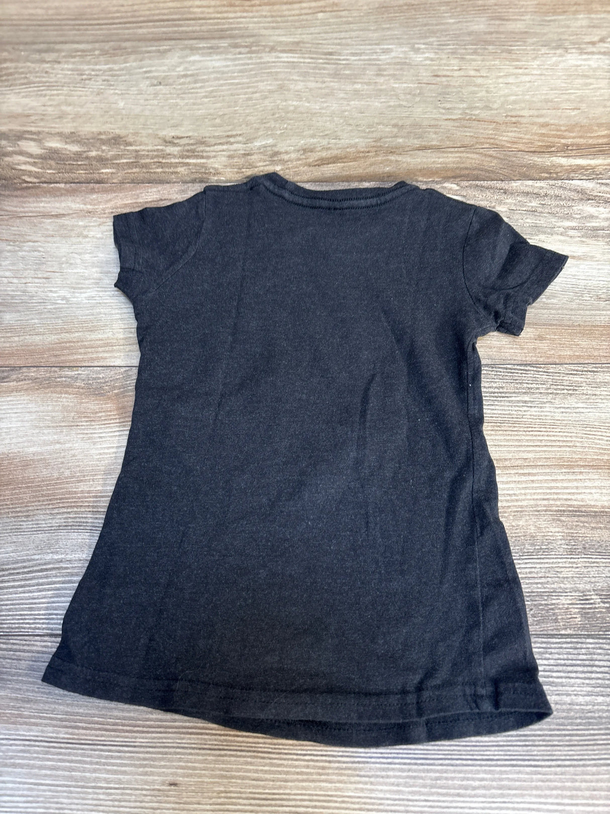 Back view of Grey Instant Message Wicked Glenda shirt size 2T showing plain back and short sleeves on wood background