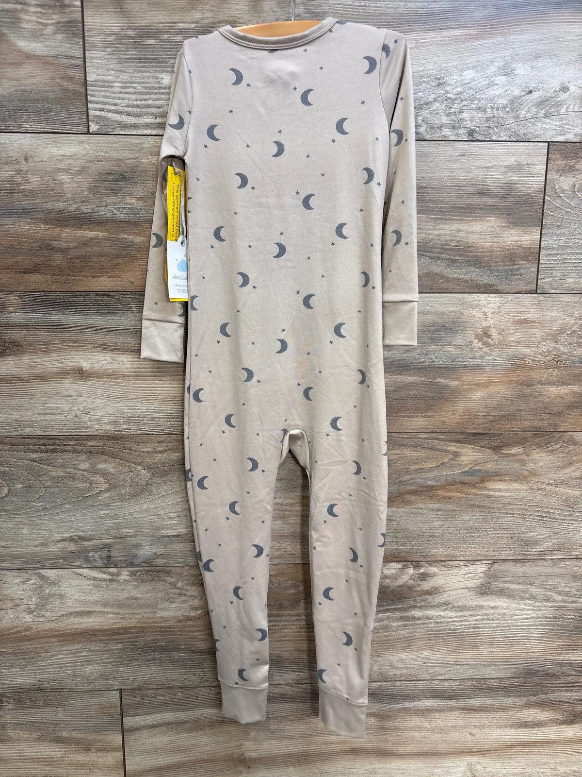 Front view of a tan Cloud Island moon sleeper in size 4T, showcasing a crescent moon and star print with long sleeves and cuffs
