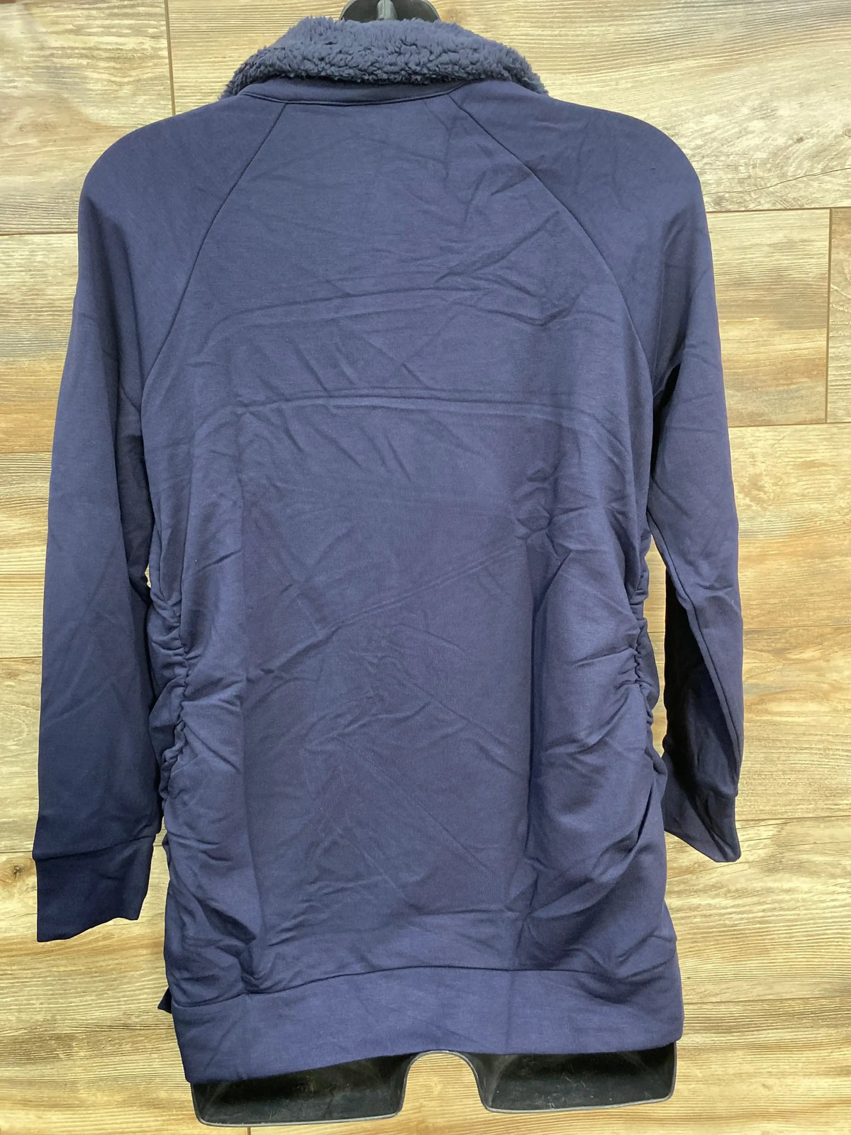 Back view of Isabel maternity navy sweatshirt size large showing sherpa collar and side ruching on wood background