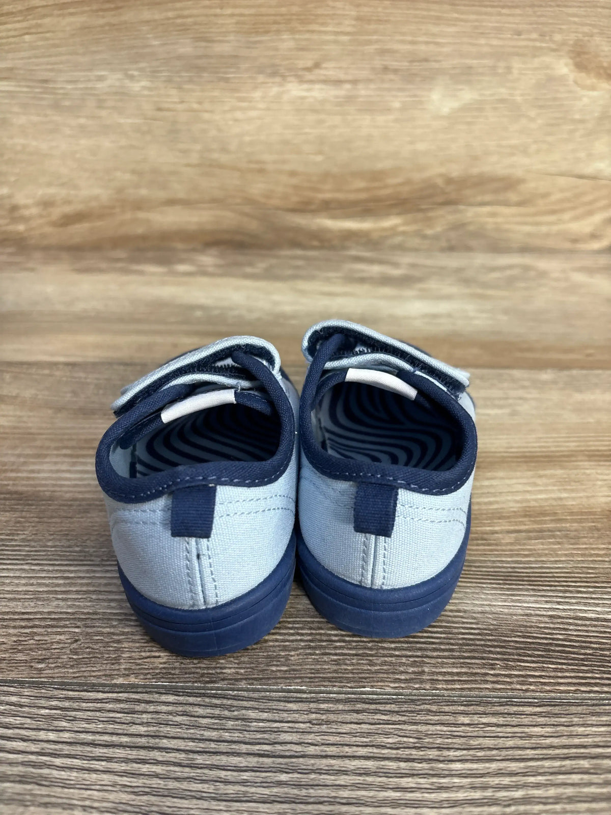 Rear view of Magical Internet Money Two Strap Bump Tow Sneakers showcasing blue and navy two strap design with a wood floor background