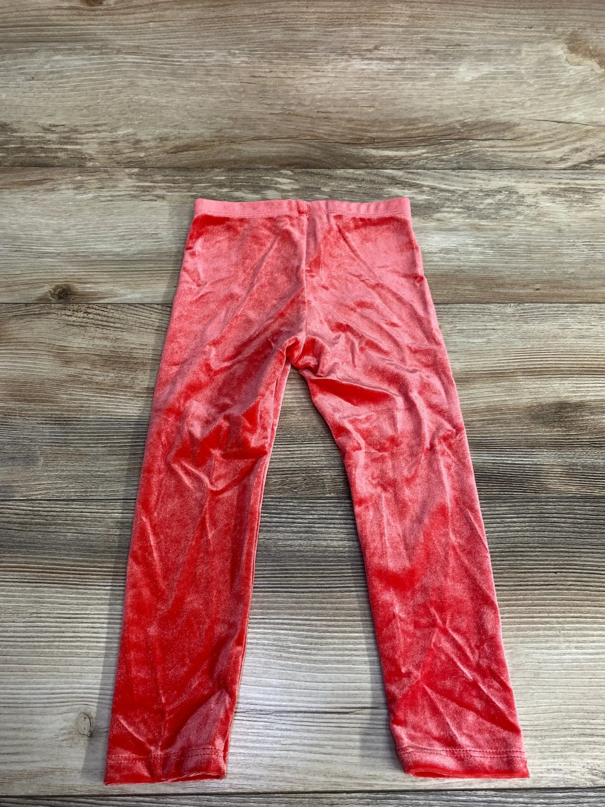 Red velvet kids leggings on wood background, children's resale clothing