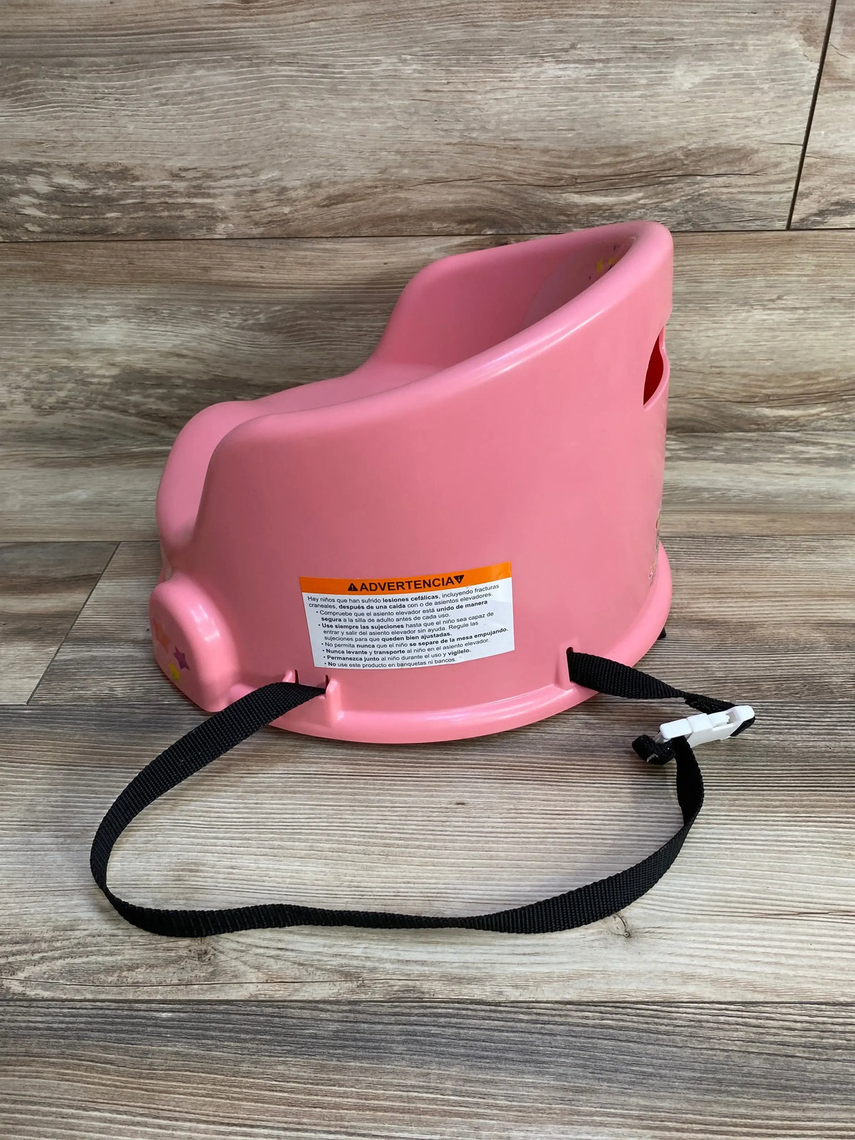 Side view of pink Cocomelon 15-inch children’s floor seat showing high back and attached black safety strap on wood floor