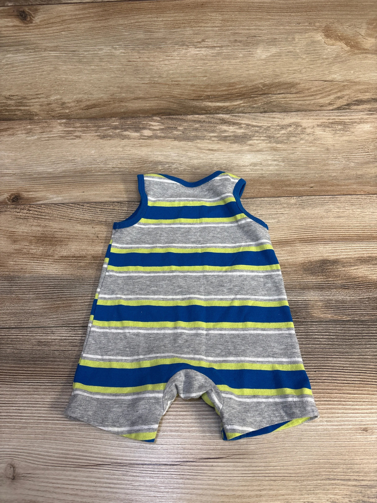Striped baby romper with blue, gray, and green lines on wooden floor