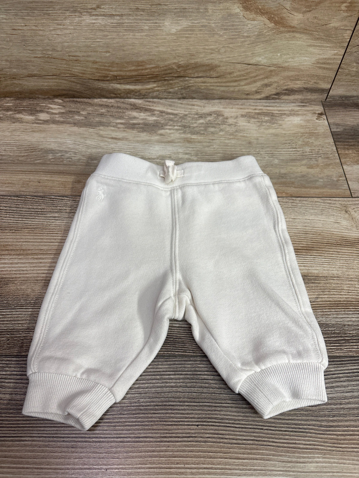 Ivory baby joggers from Me 'n Mommy To Be laid flat on a wooden surface