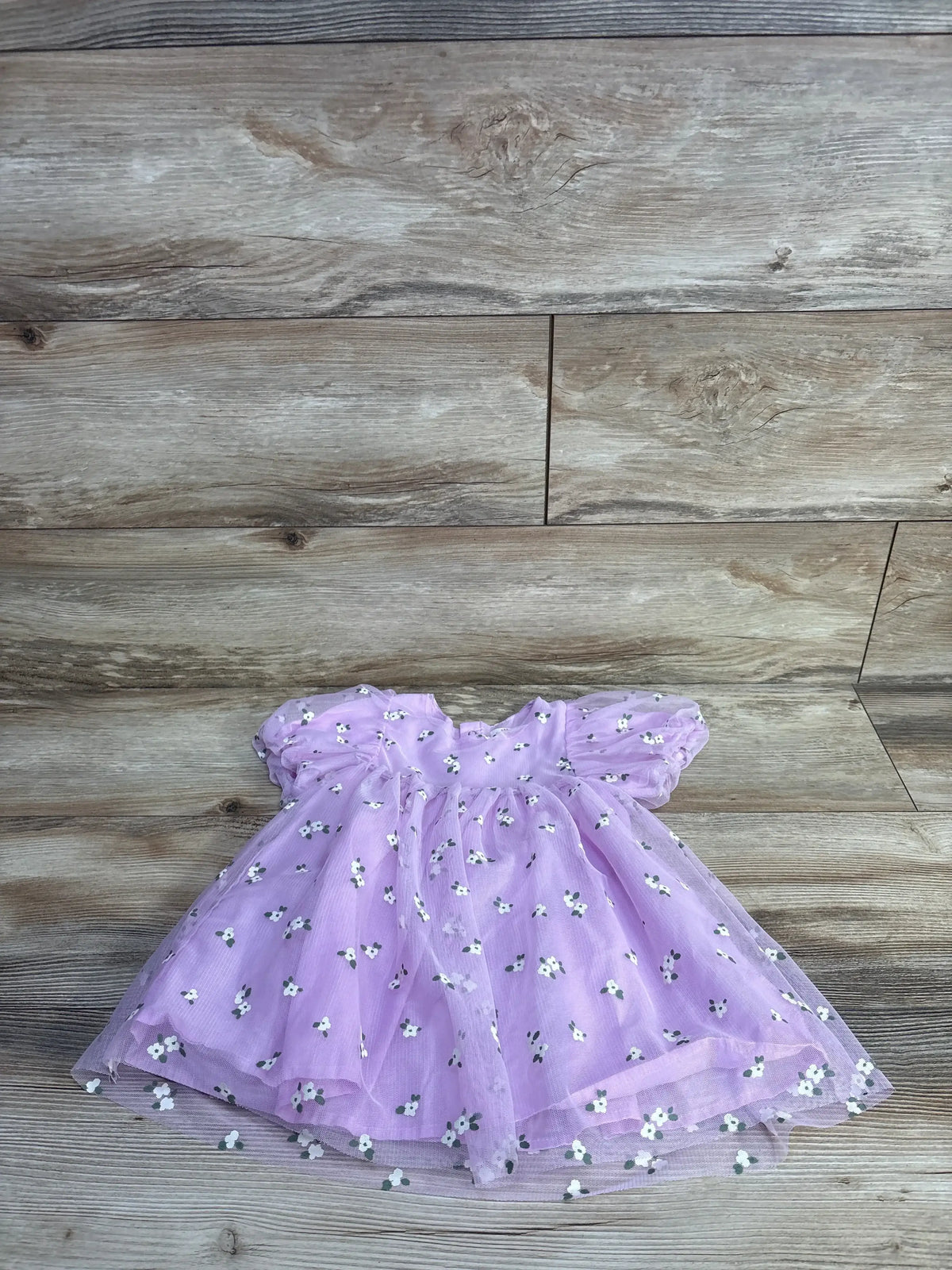 Flat lay of Cat & Jack lilac daisy tulle toddler dress size 18 months showing puff sleeves and layered skirt on light wood background