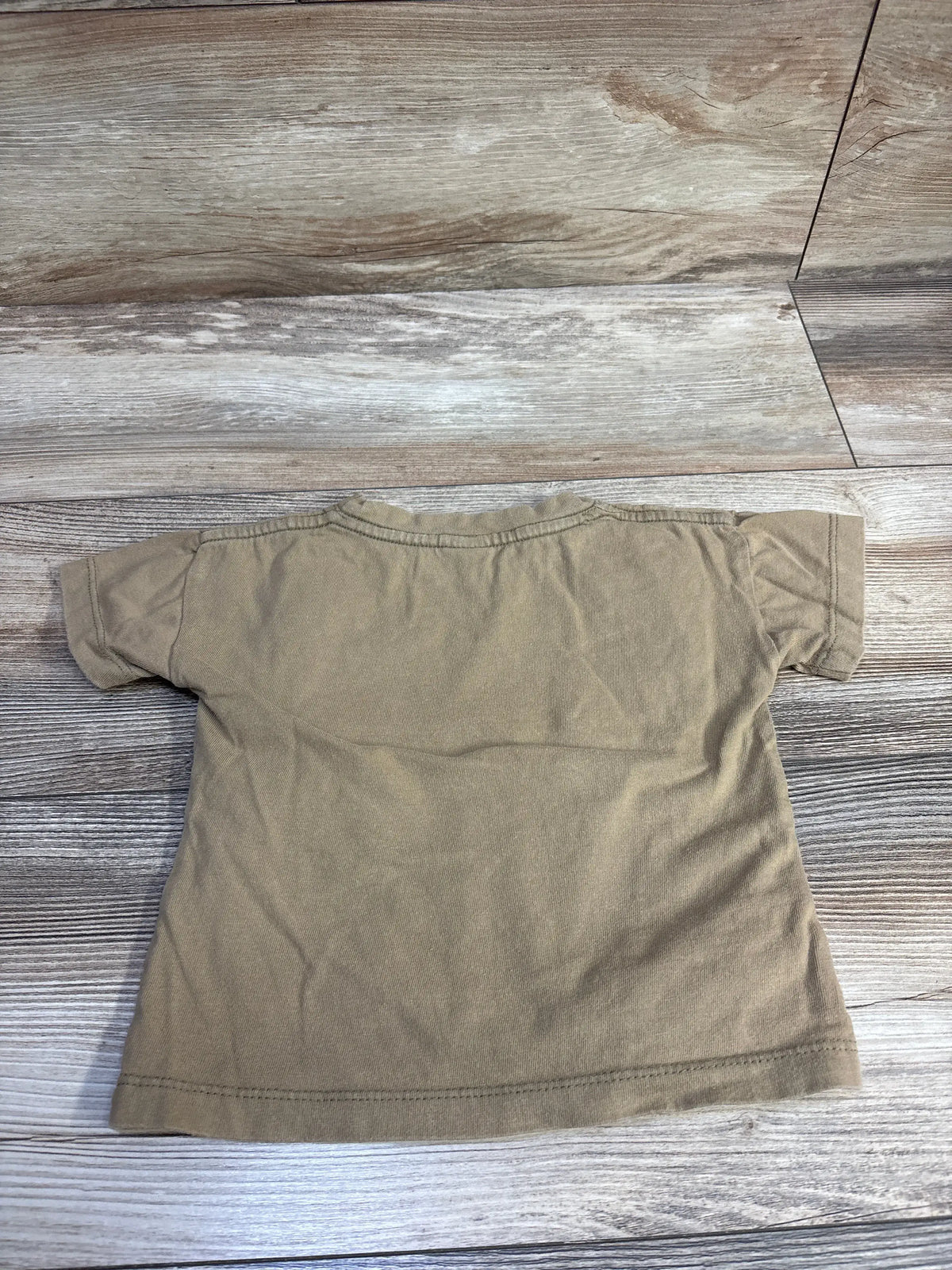 Back view of Silver Lake Cloth solid shirt in tan showcasing short sleeves with wood-look flooring