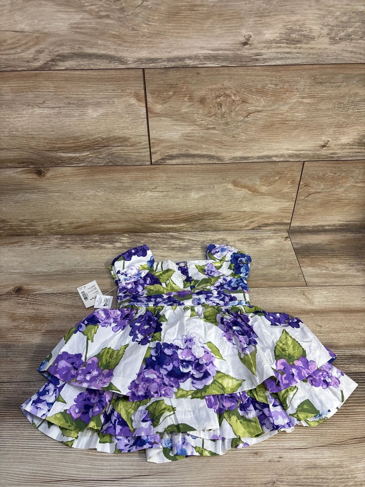 Overhead view of Gymboree toddler dress with purple floral print, flutter sleeves, shirred waist, and layered ruffle hem