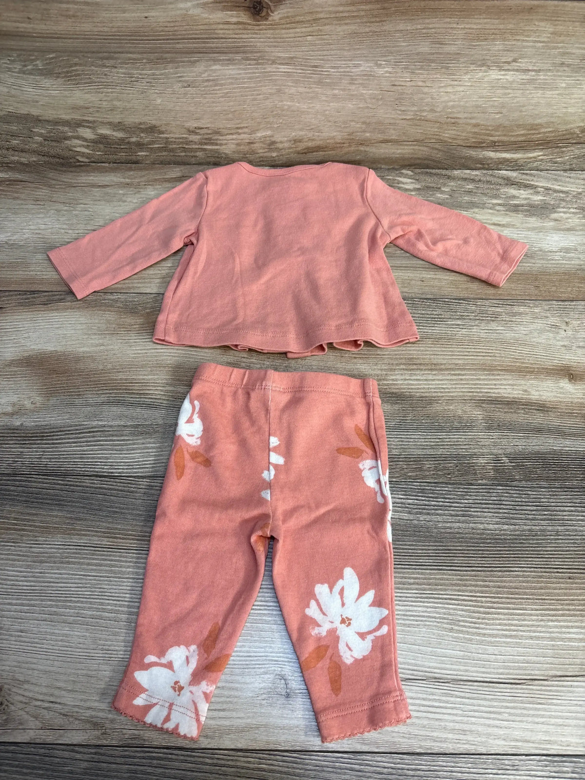 Flat lay of Carter’s shirt and leggings set (size 3M) showcasing pink long-sleeve top and matching floral-print leggings on wood background