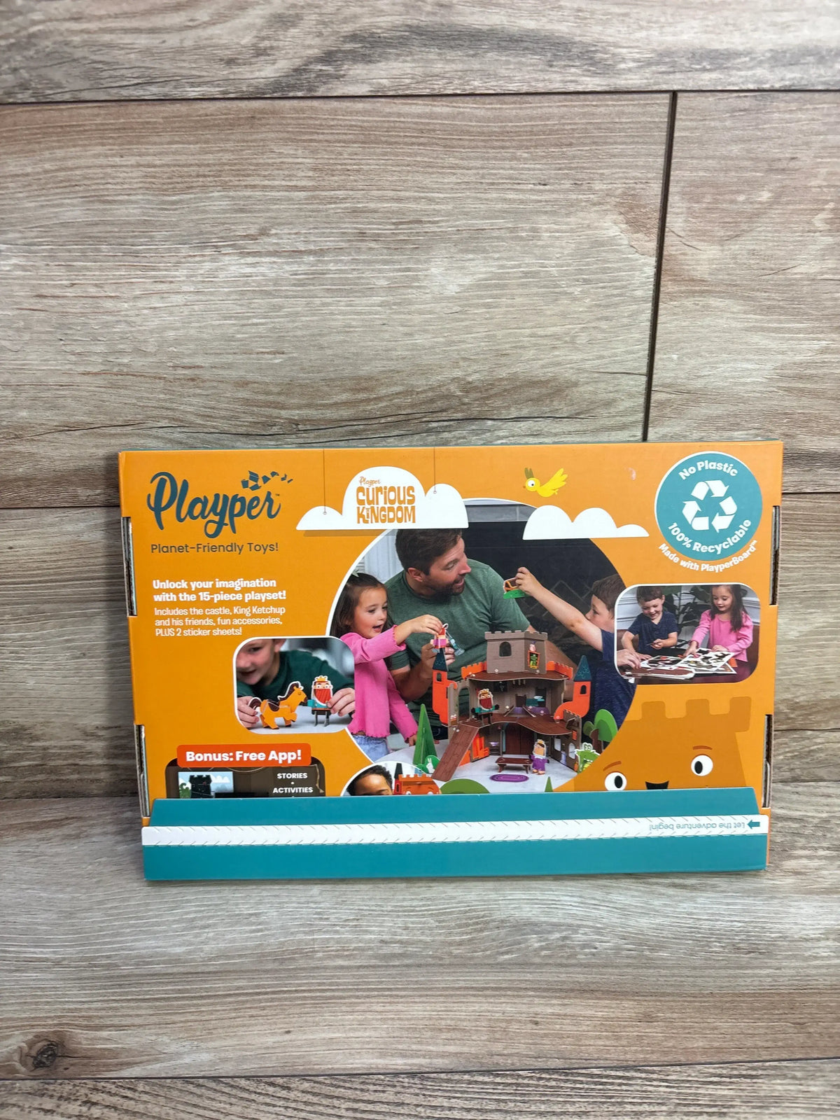 Front view of Playper Curious Kingdom castle box showing castle art, family playing and recyclable badge on orange packaging