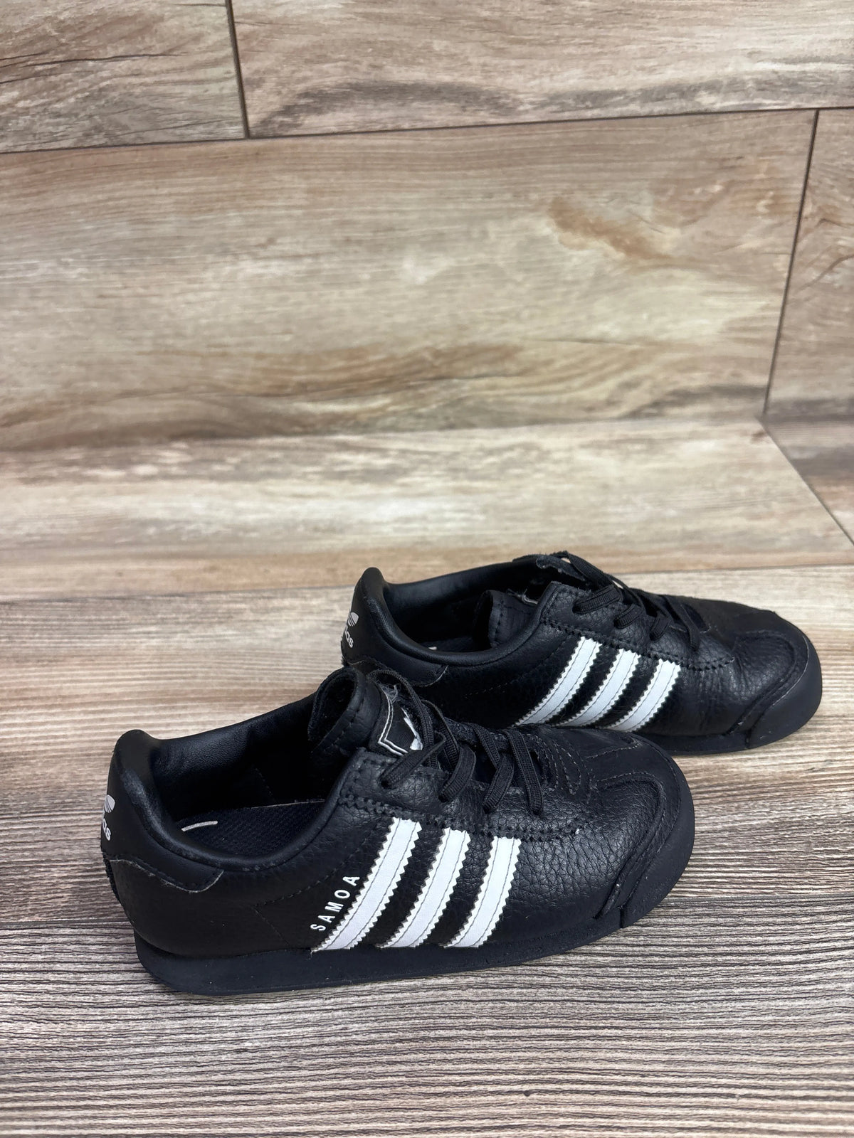 Pair of black Me n Mommy To Be sneakers with three white stripes and SAMOA branding.