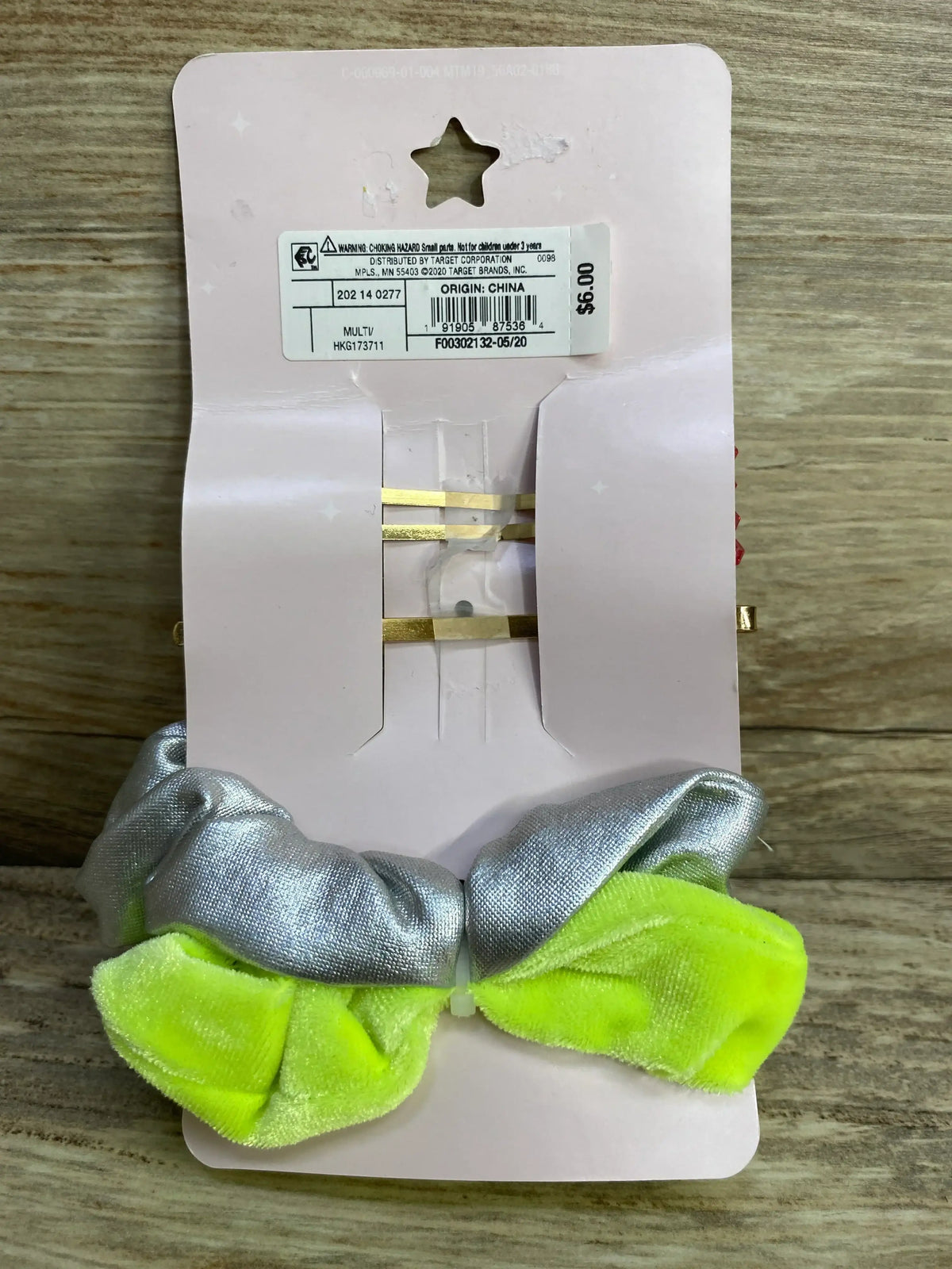 Front view of More Than Magic 4-pack with silver and neon yellow scrunchies and two gold hair clips on a pink display card