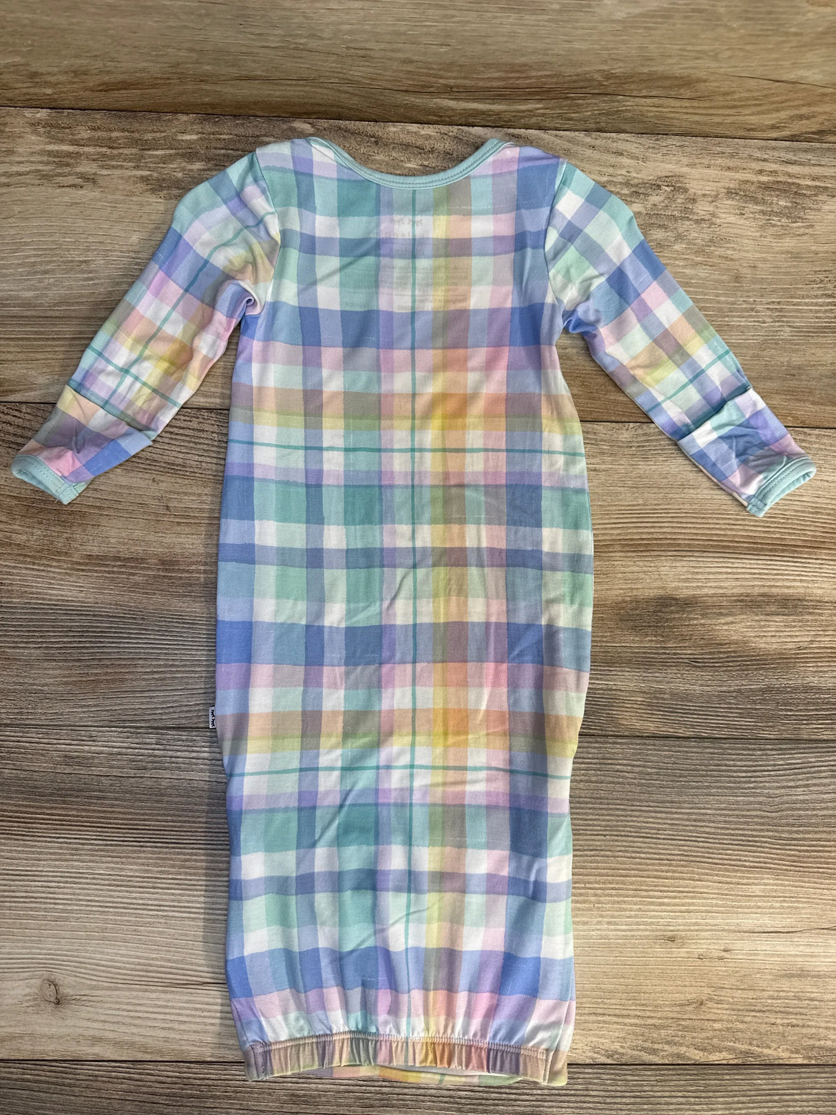 Pastel plaid baby sleeper gown with long sleeves on wood background