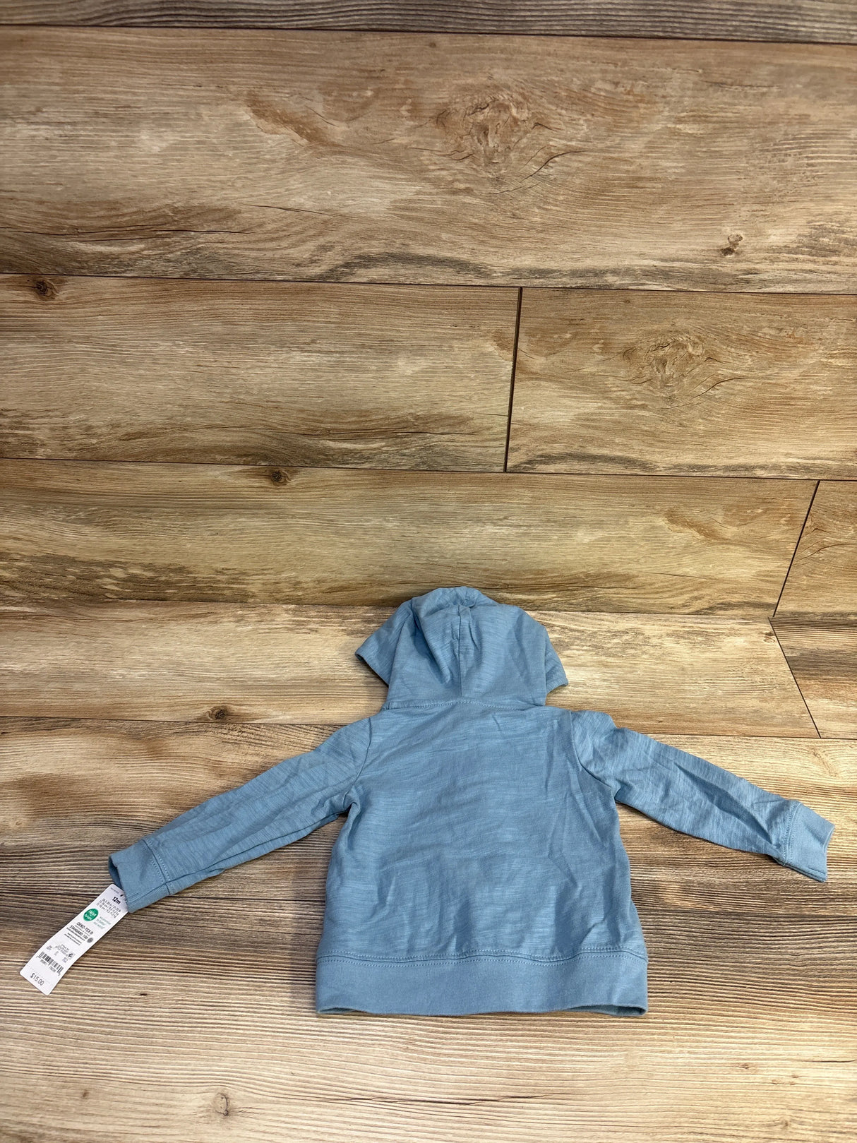 Back view of Just One You shark full-zip baby jacket in blue size 12M showing hood and long sleeves on wood background