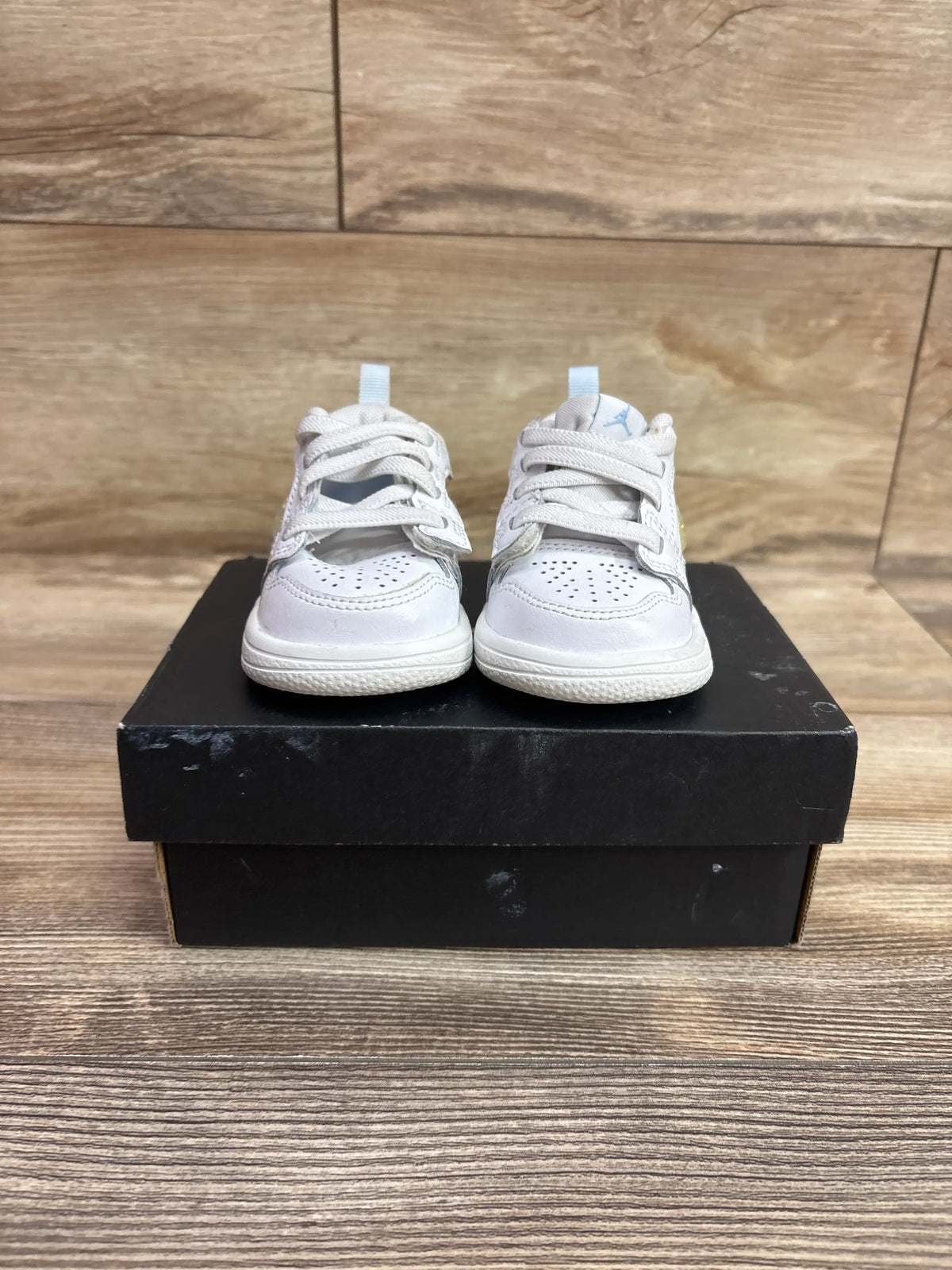 Front view of Air Jordan 4 Retro TD Hyper Violet sneakers with white uppers and light blue accents on a black shoebox