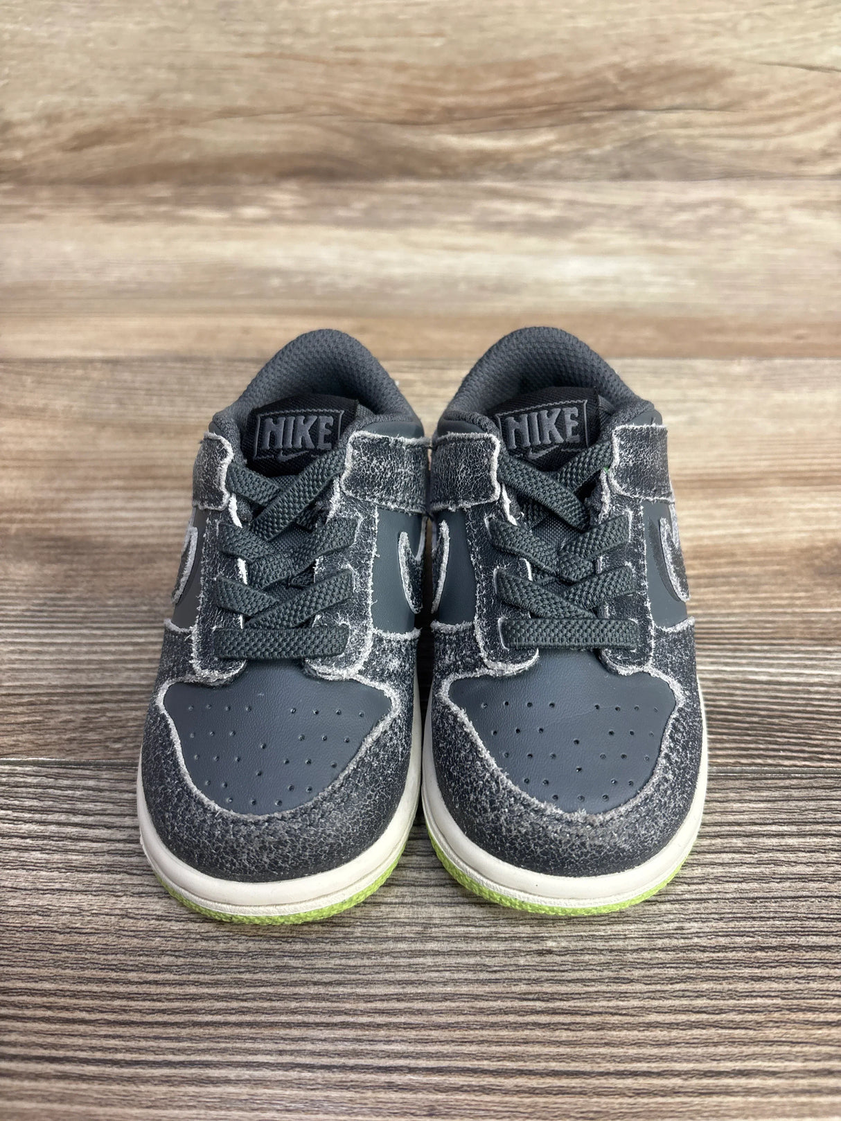 Gray Nike toddler sneakers with green soles, ideal for kids' active play and resale shopping.