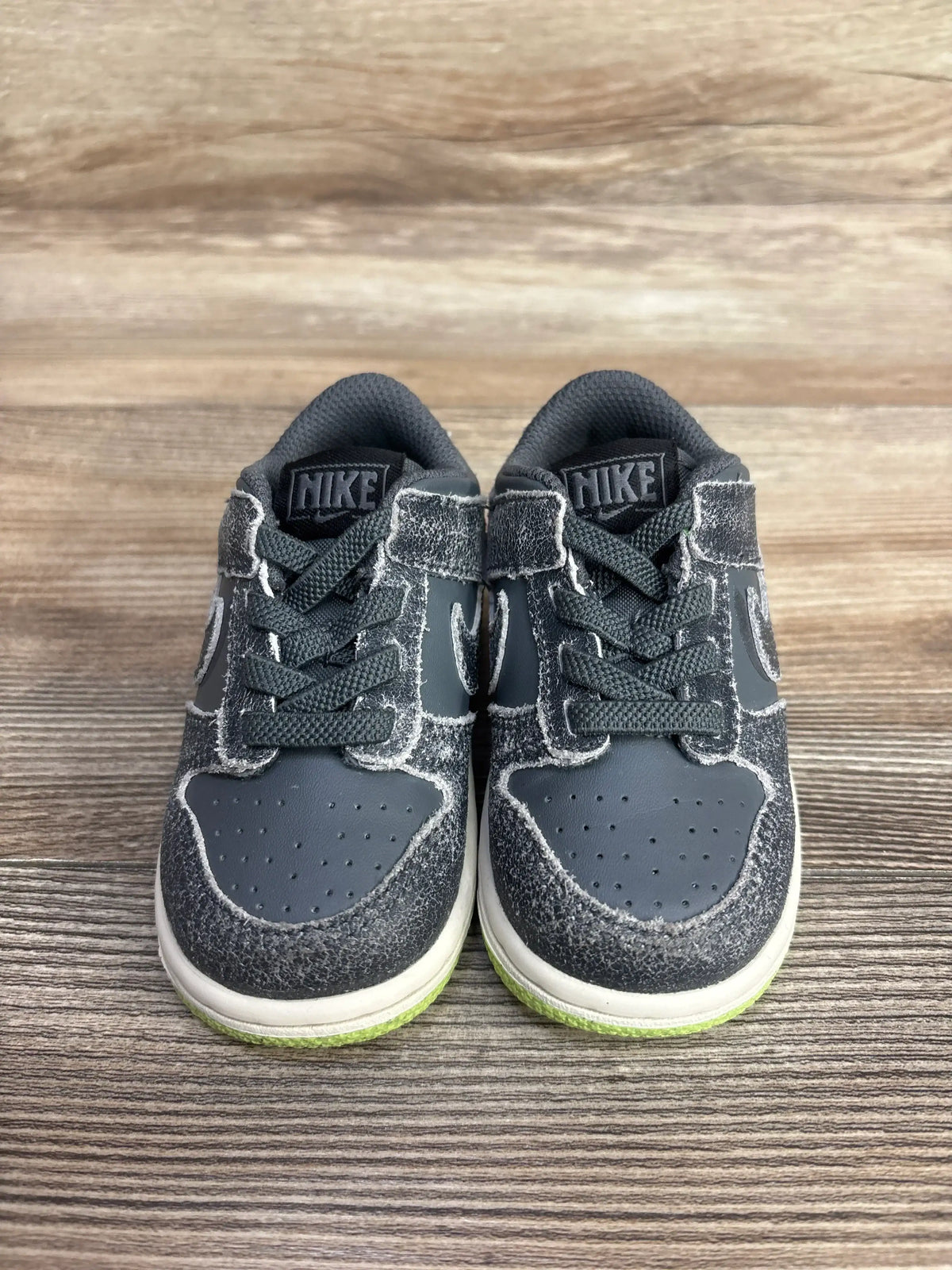 Gray Nike toddler sneakers with green soles, ideal for kids' active play and resale shopping.