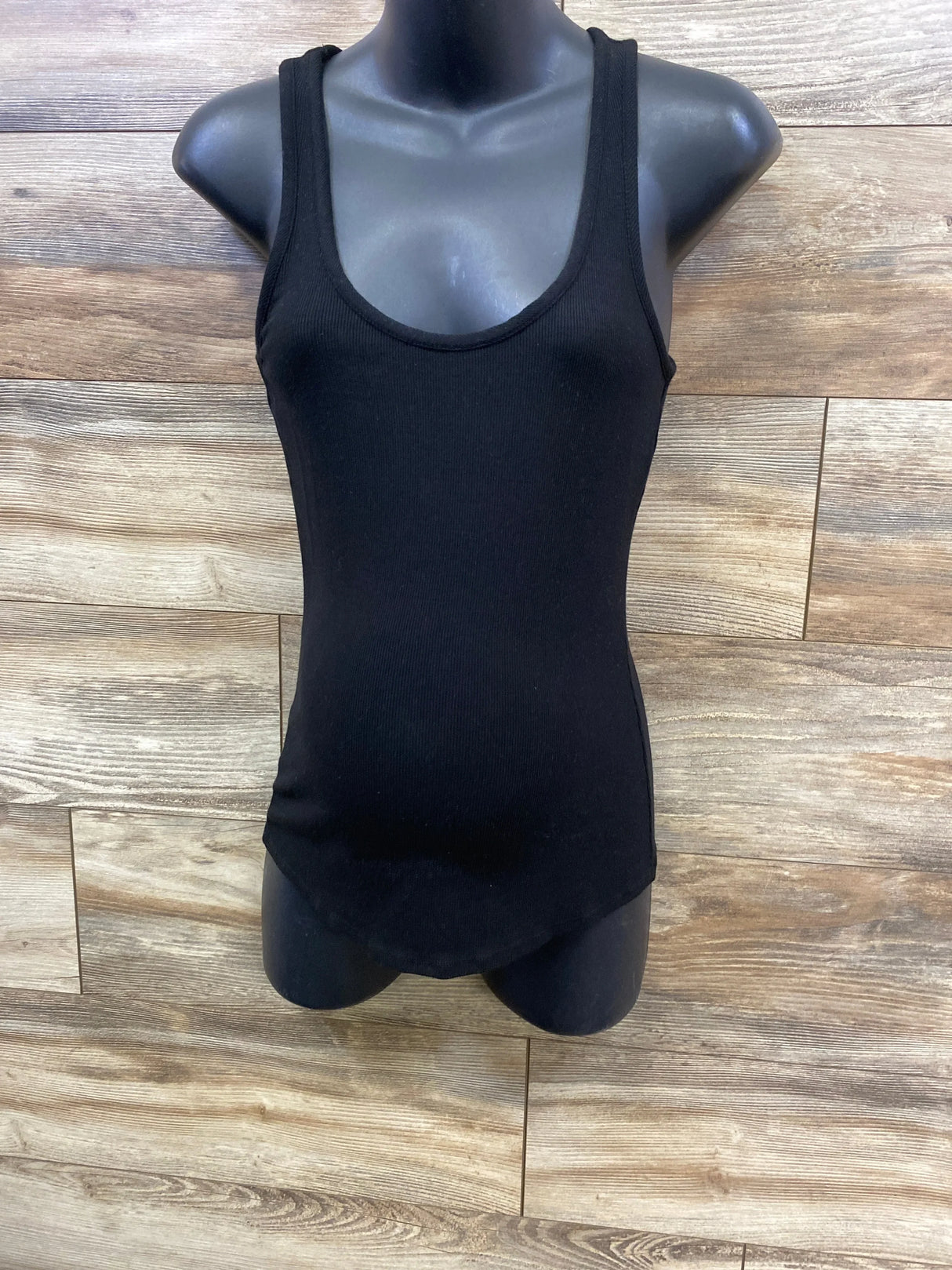 Black ribbed tank top for kids on mannequin with wood background