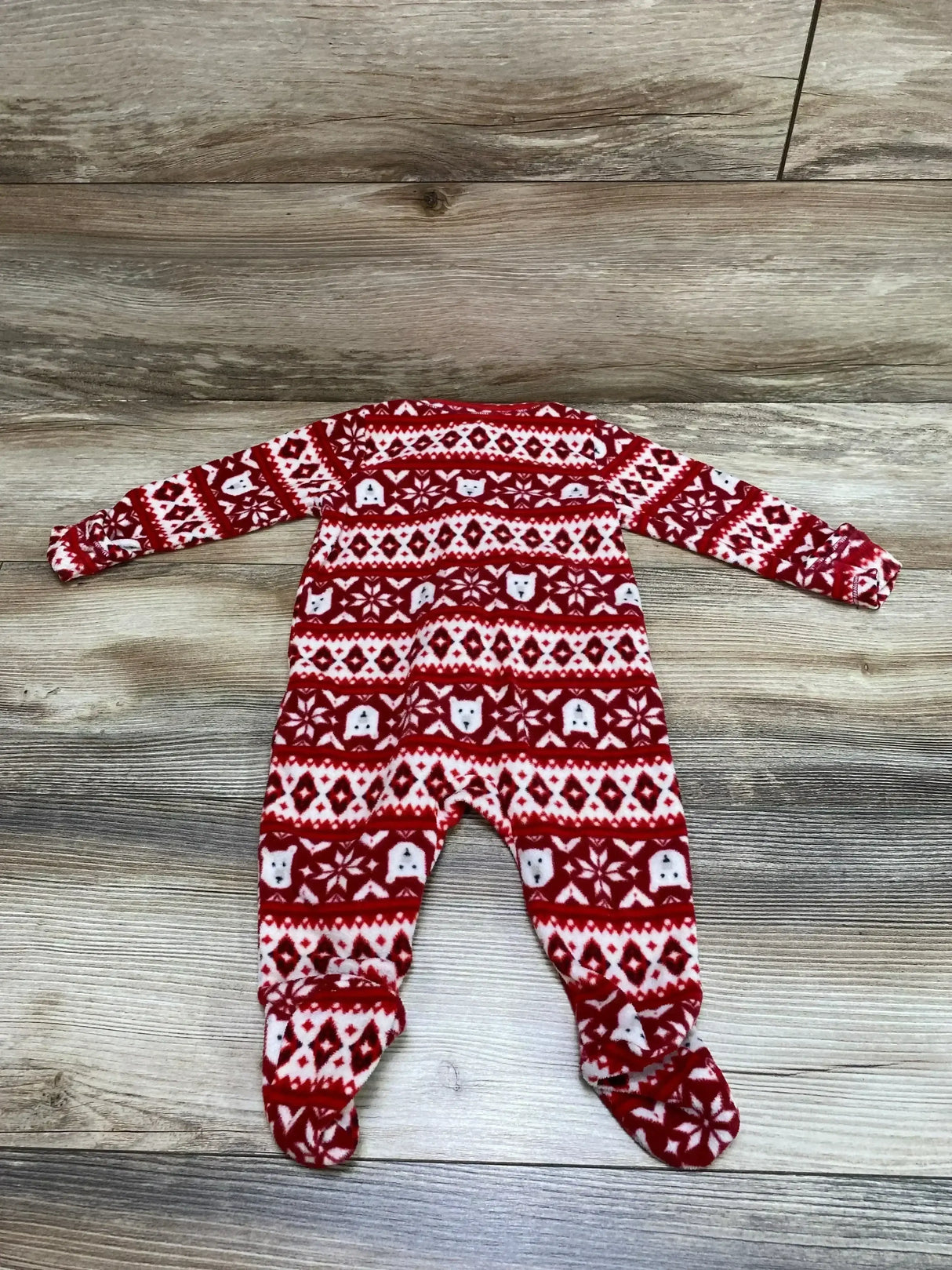 Flat lay front view of red Fair Isle footed baby sleeper (3-6 months) showing long sleeves and knit-pattern fleece on wood floor