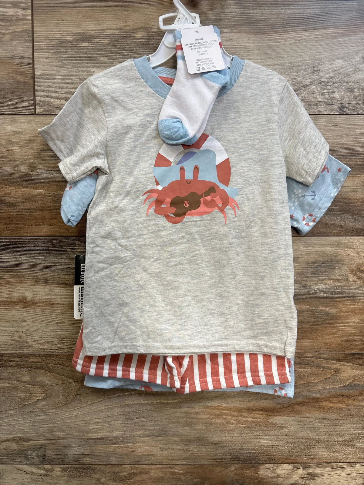 Front view of 4-piece toddler set showing gray tee with crab and ukulele, coral-striped shorts and blue socks on wood floor