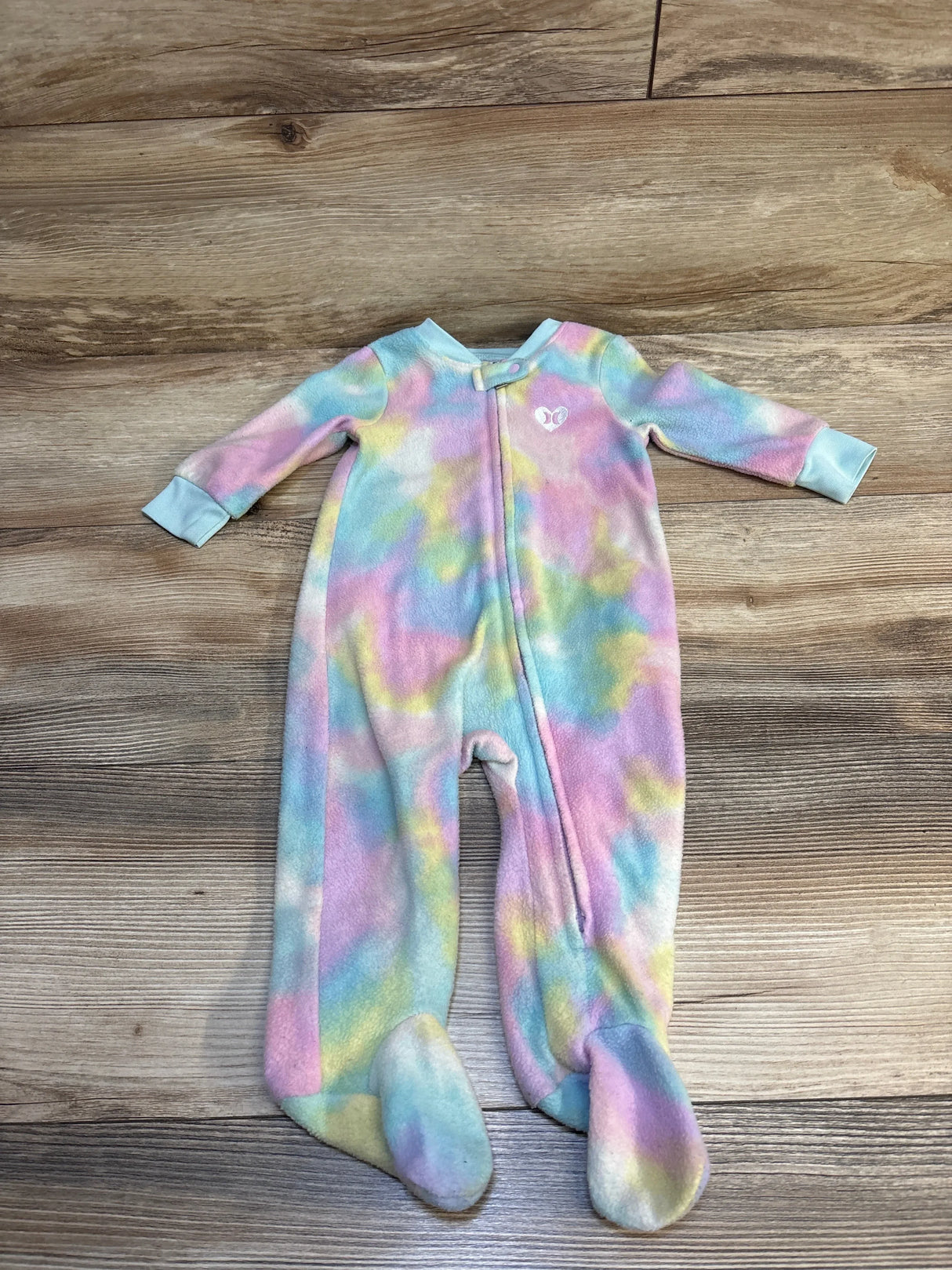 Pastel tie-dye baby footed sleeper with front zipper on wood floor
