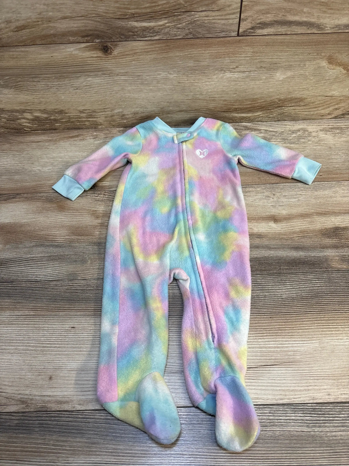 Pastel tie-dye baby footed sleeper with front zipper on wood floor