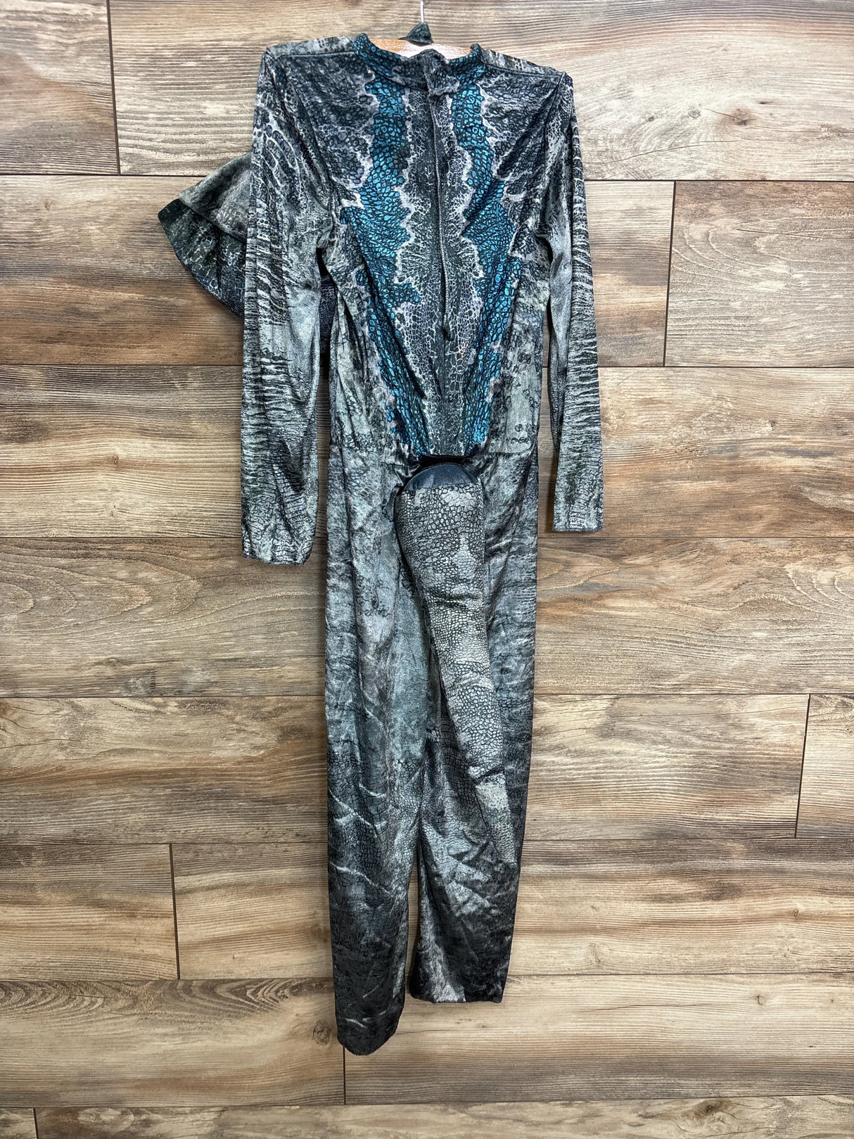Kids' blue and gray snake print jumpsuit with long sleeves, laid on wood floor