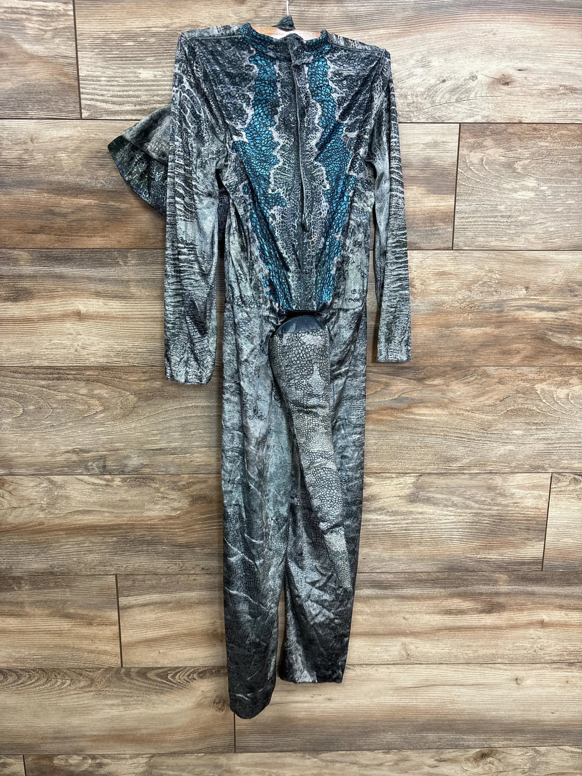 Front view of a blue and gray Jurassic World dinosaur costume showcasing long sleeves and a wood-floor background