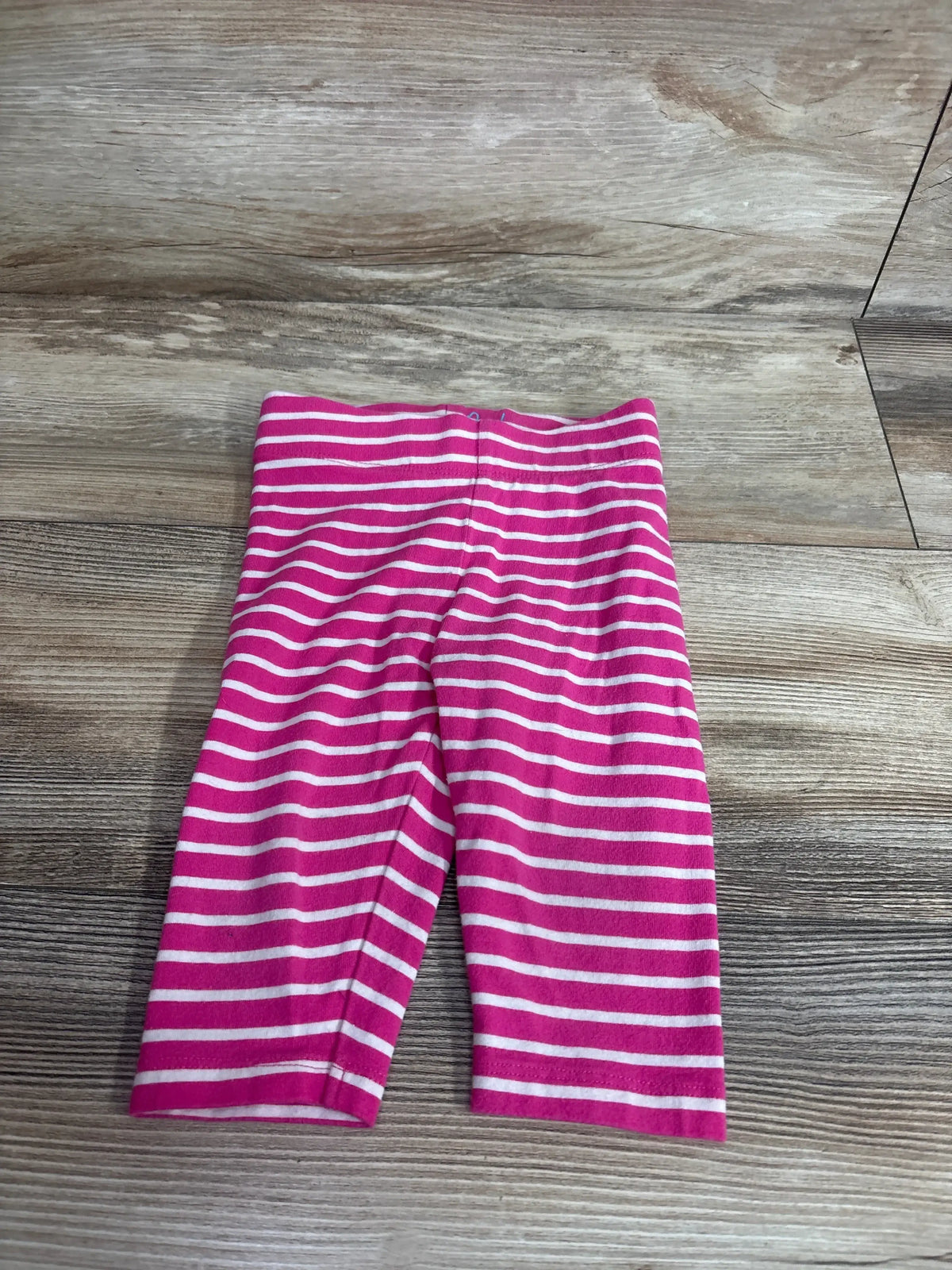 Flat lay of Mini Boden toddler leggings (2T) showing pink and white stripes and elastic waistband on wood floor