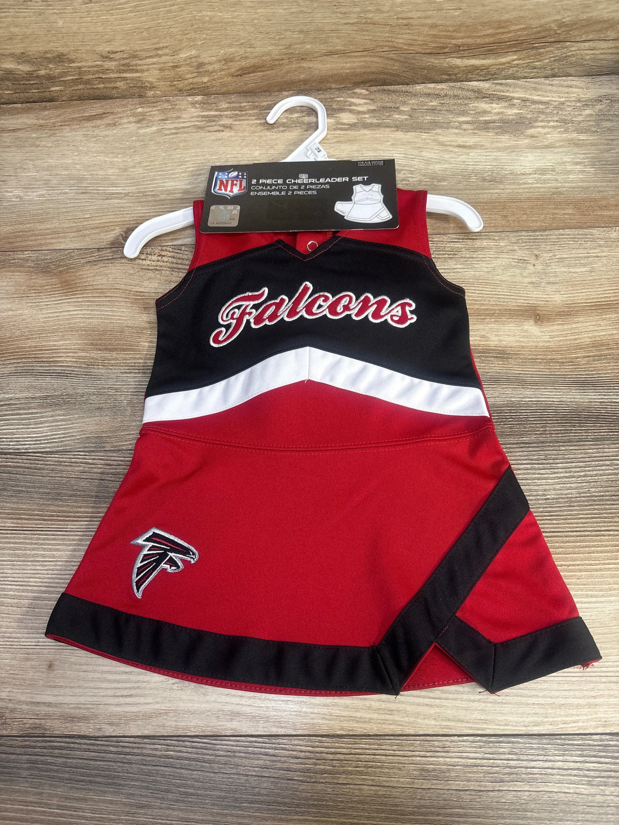 Red and black Atlanta Falcons cheerleader dress with logo on wooden background