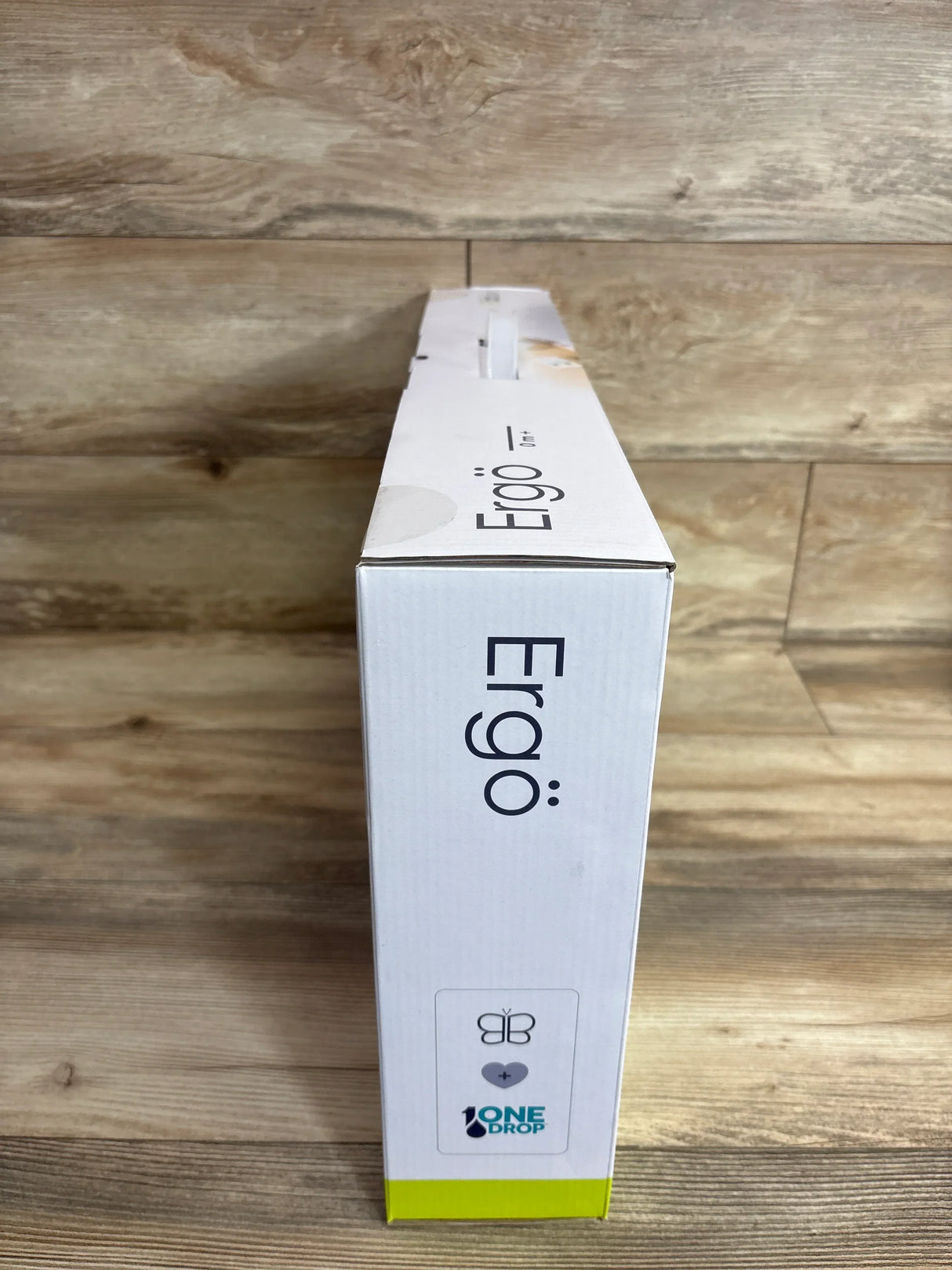 Side view of bbluv Ergo complete set box showcasing vertical "Ergo" logo and lime-green trim on a wooden surface