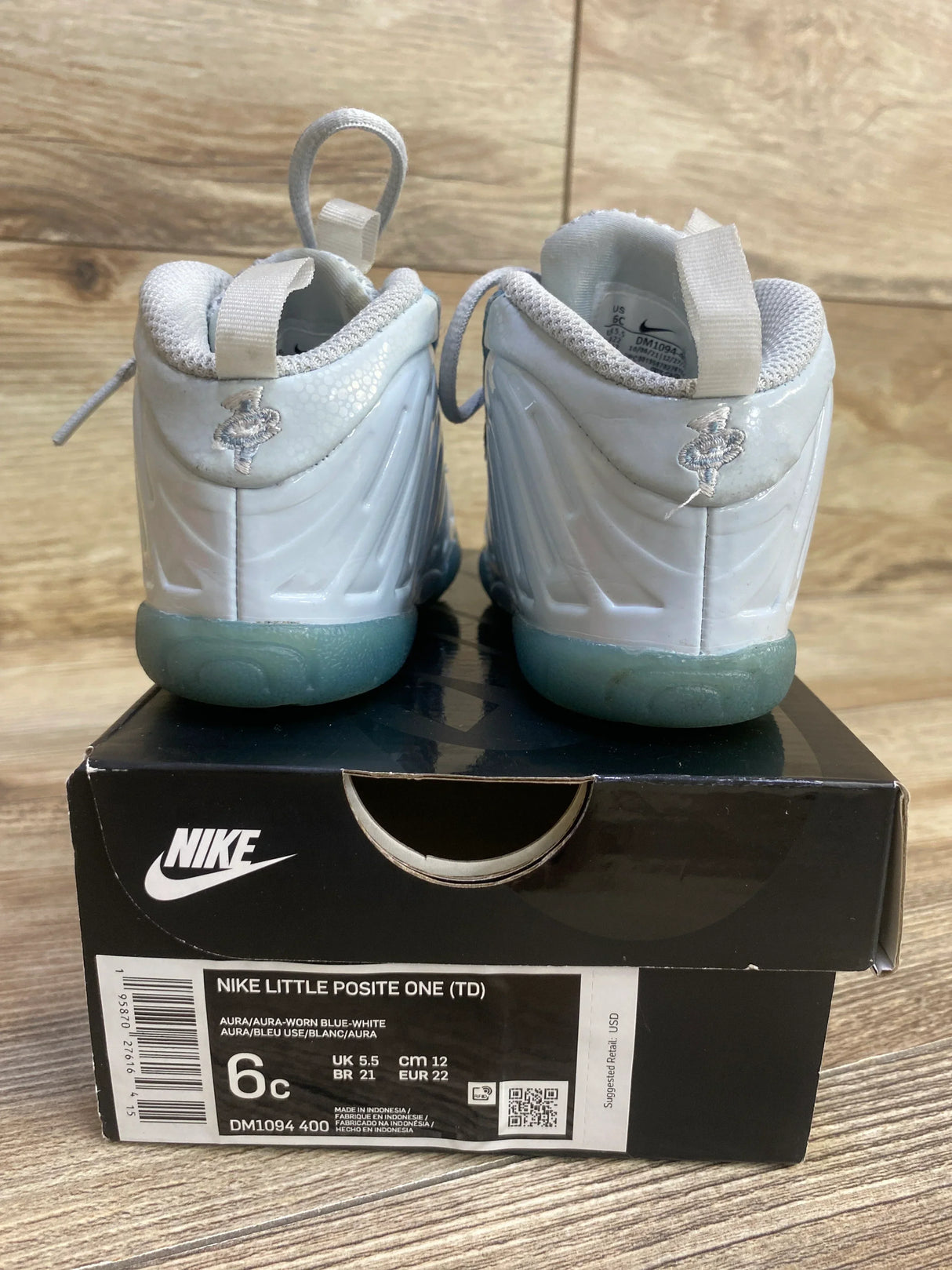 Back view of Nike Little Posite One size 6C showing glossy white shell upper and translucent icy blue soles on Nike box