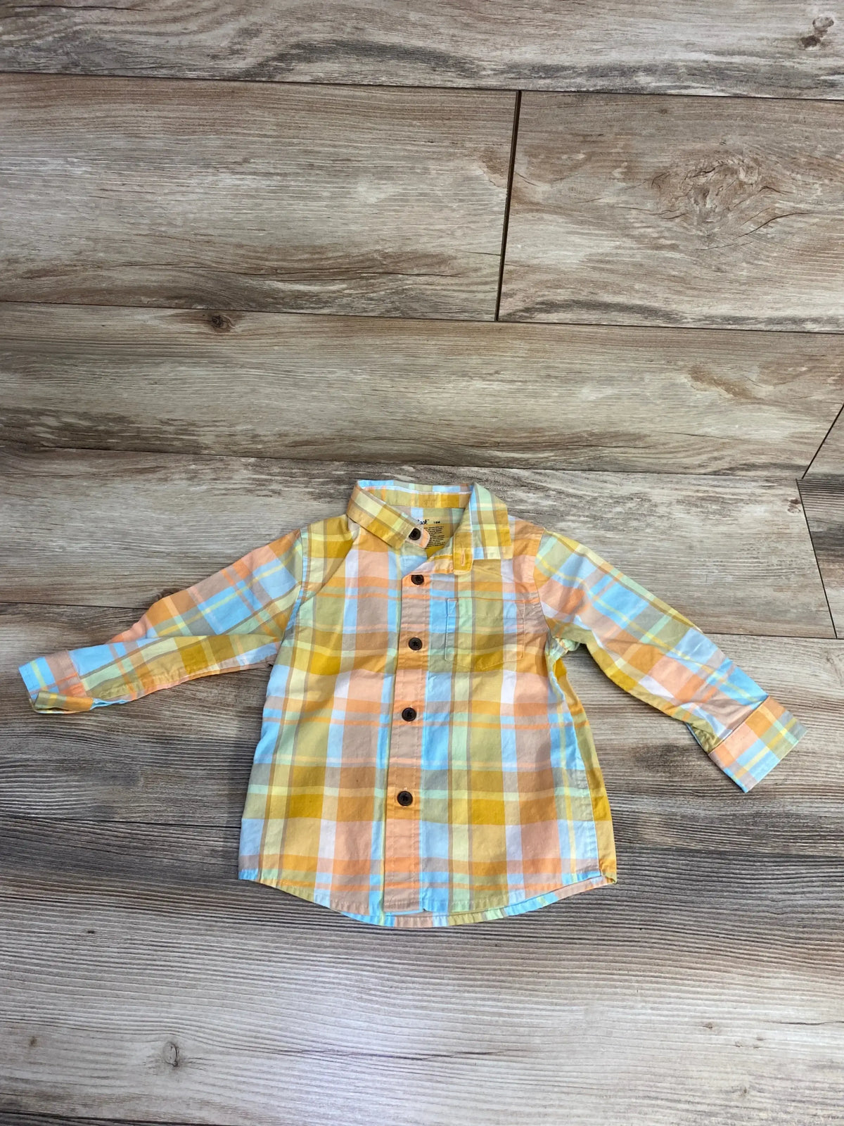 Children's long sleeve plaid shirt in yellow, orange, blue, and white on wooden floor
