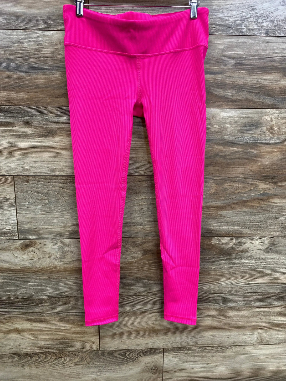 Front view of pink Gap Fit maternity leggings with under-belly ribbed waistband and blackout fabric on wooden background