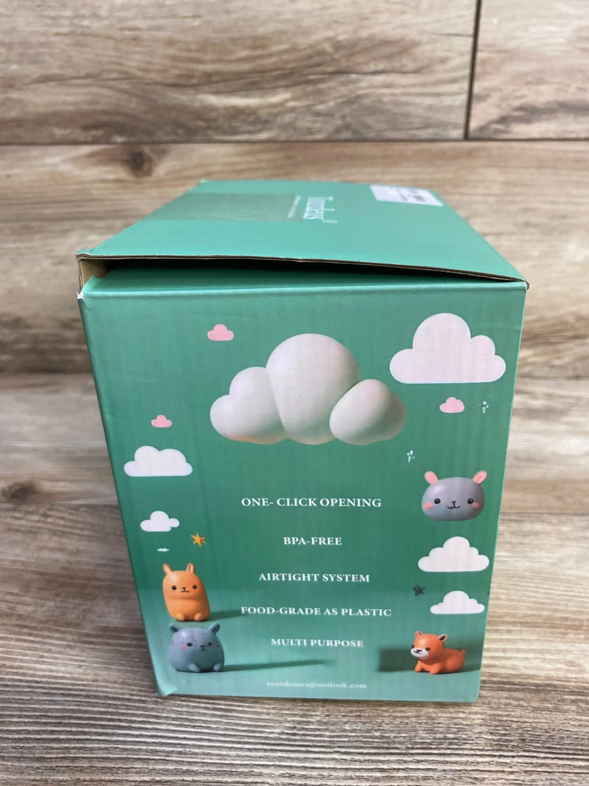 Front of Ankou formula container box with ONE-CLICK OPENING and BPA-FREE text and cloud animal illustrations on wood surface