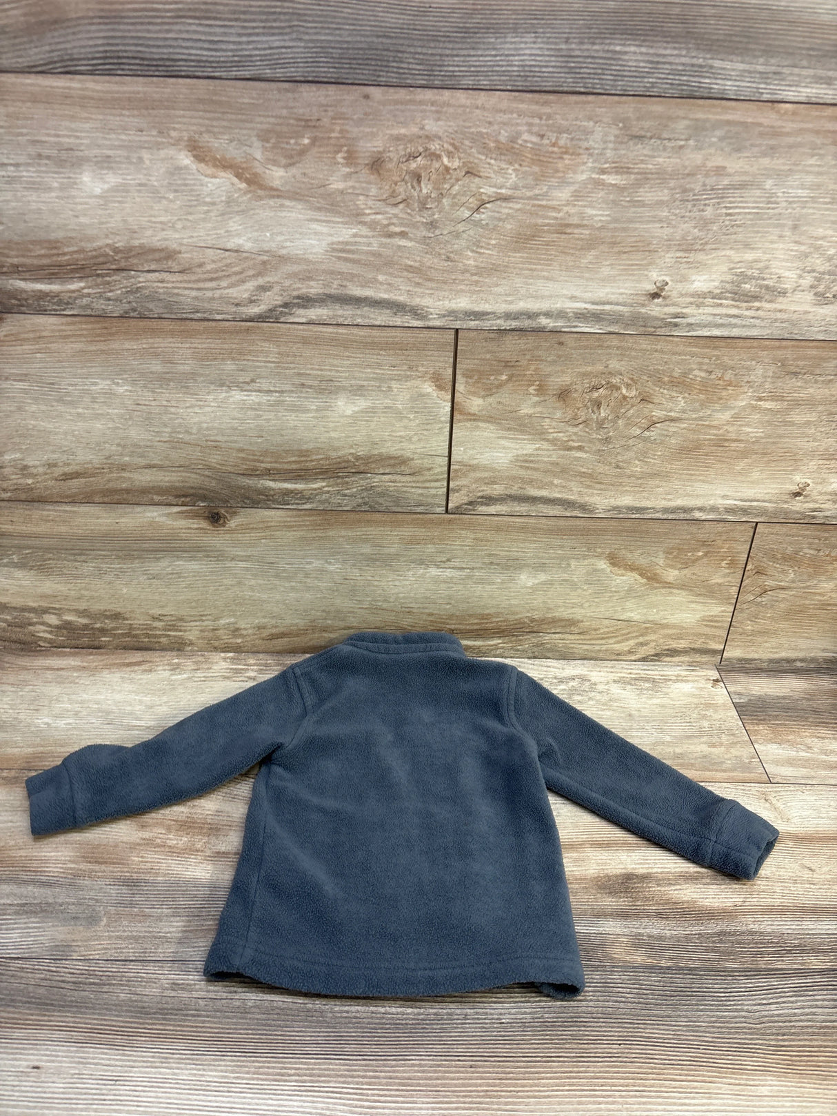 Back view of Columbia fleece full zip jacket showcasing soft fleece fabric on wood plank background, size 18-24 months