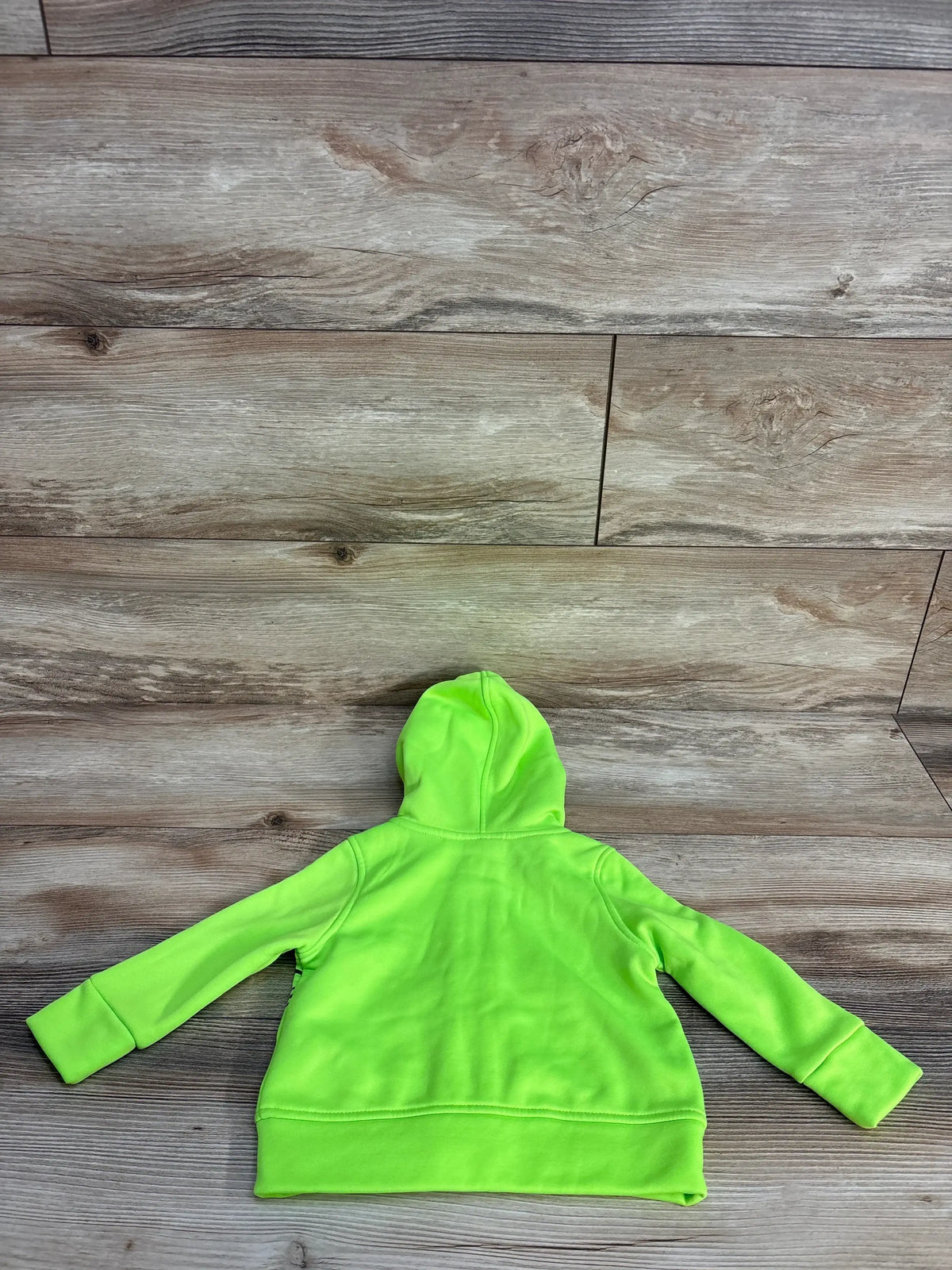 Back view of Puma full-zip toddler jacket in neon green showing hood and long sleeves on rustic wooden floor