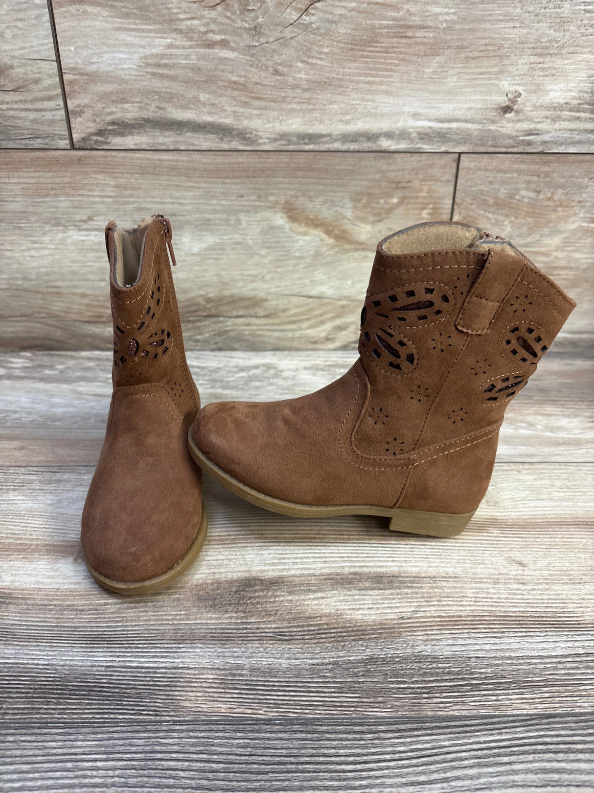 Front and side view of Rachel Shoes Lil’ Jayla toddler western boots in brown with laser-cut shaft details on wood background