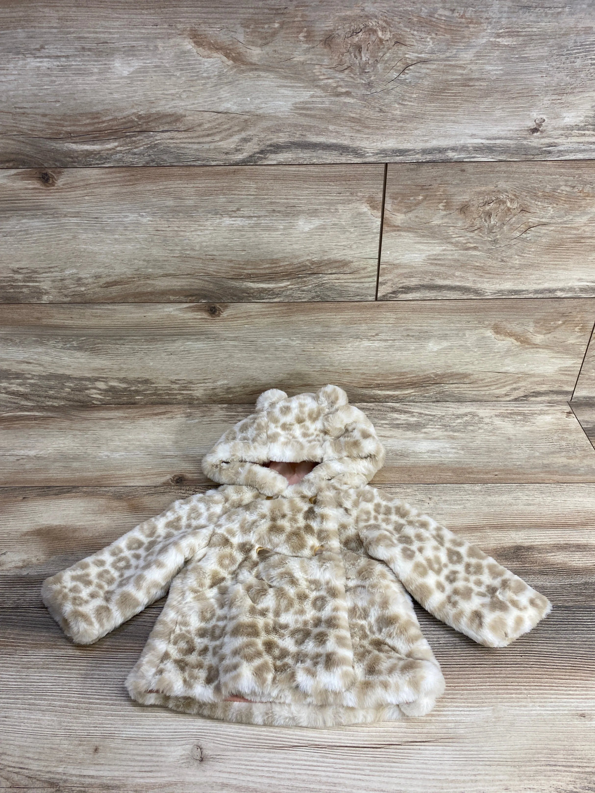 Faux fur toddler coat with leopard print pattern and hood, displayed on wooden background