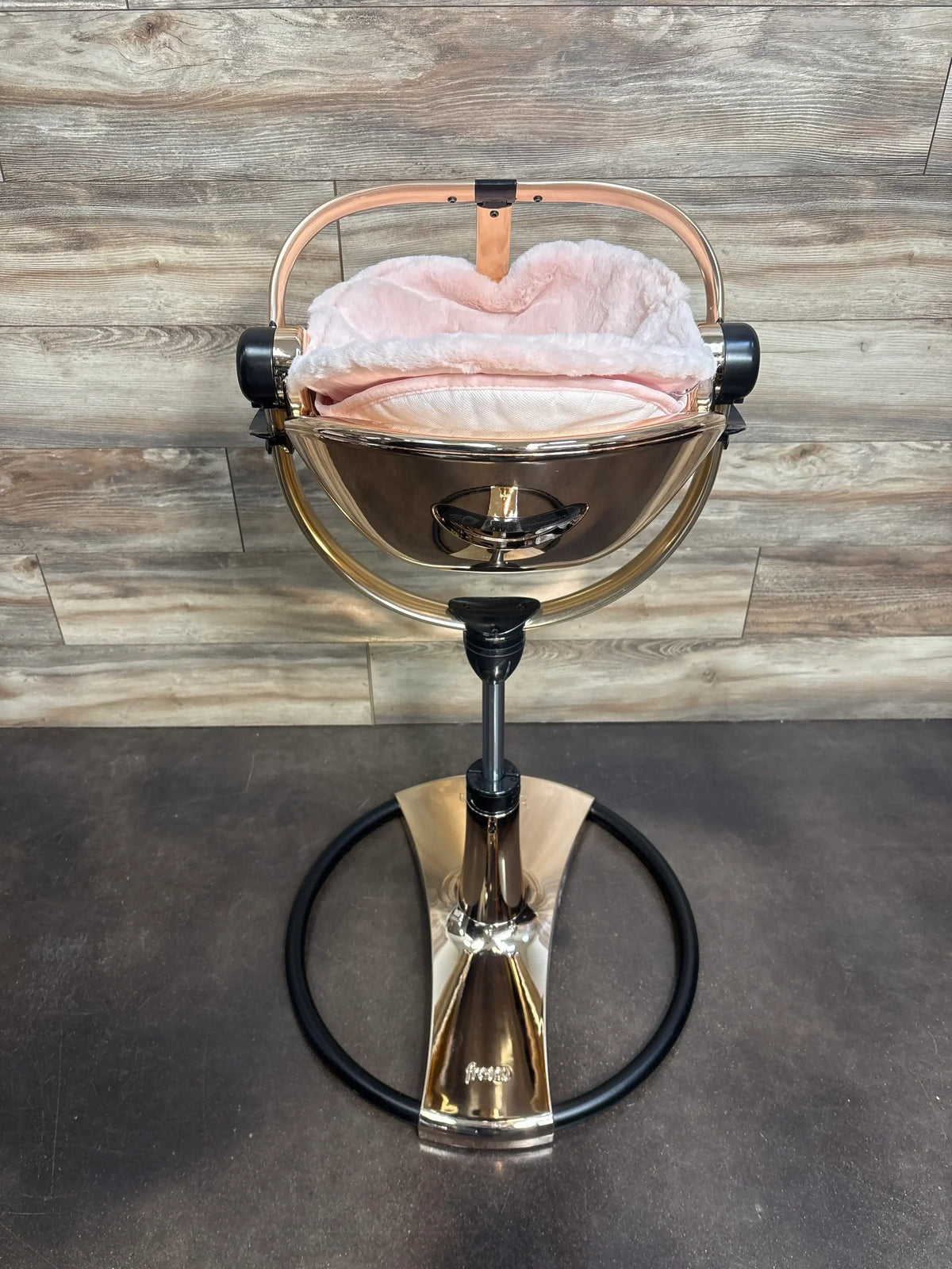 Front view of Bloom Fresco Special Edition High Chair in Rose Gold showcasing its plush pink newborn seat against a wood wall