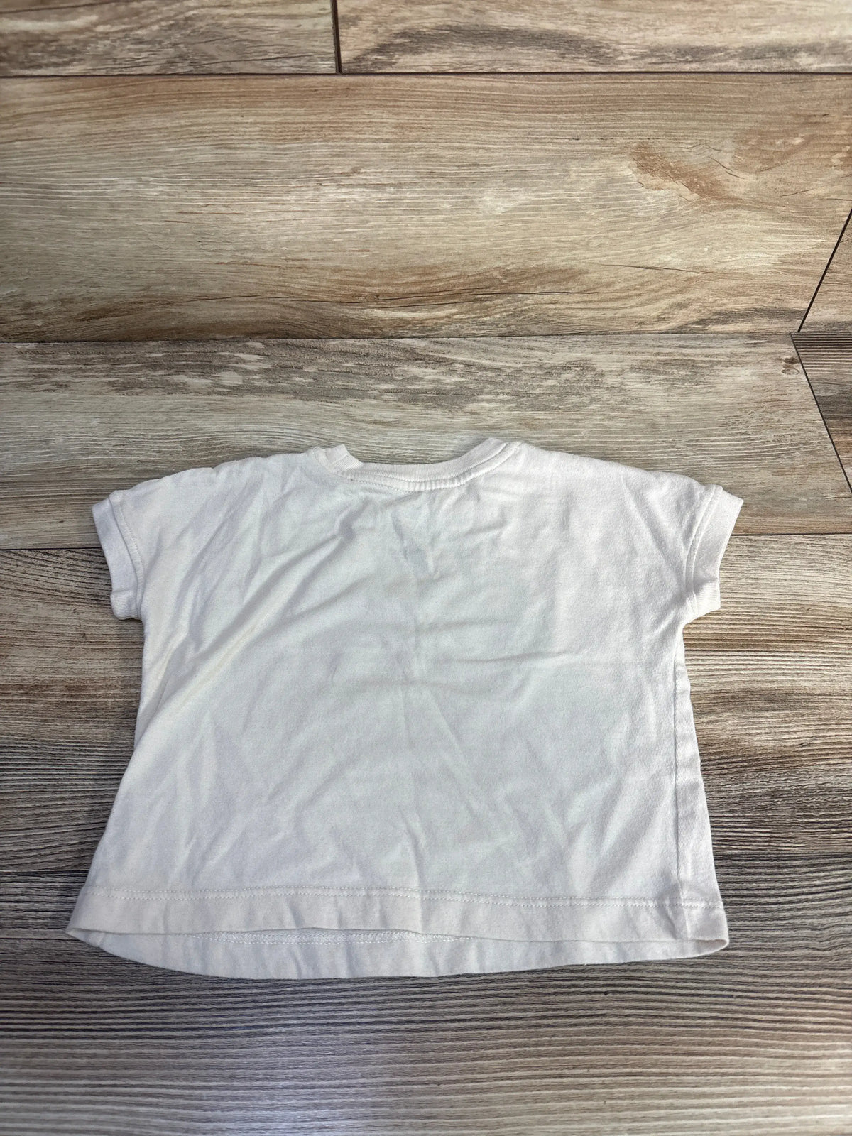Front view of Okie Dokie Sunny Vibes shirt showcasing its ivory color and short sleeves on a wood-look floor