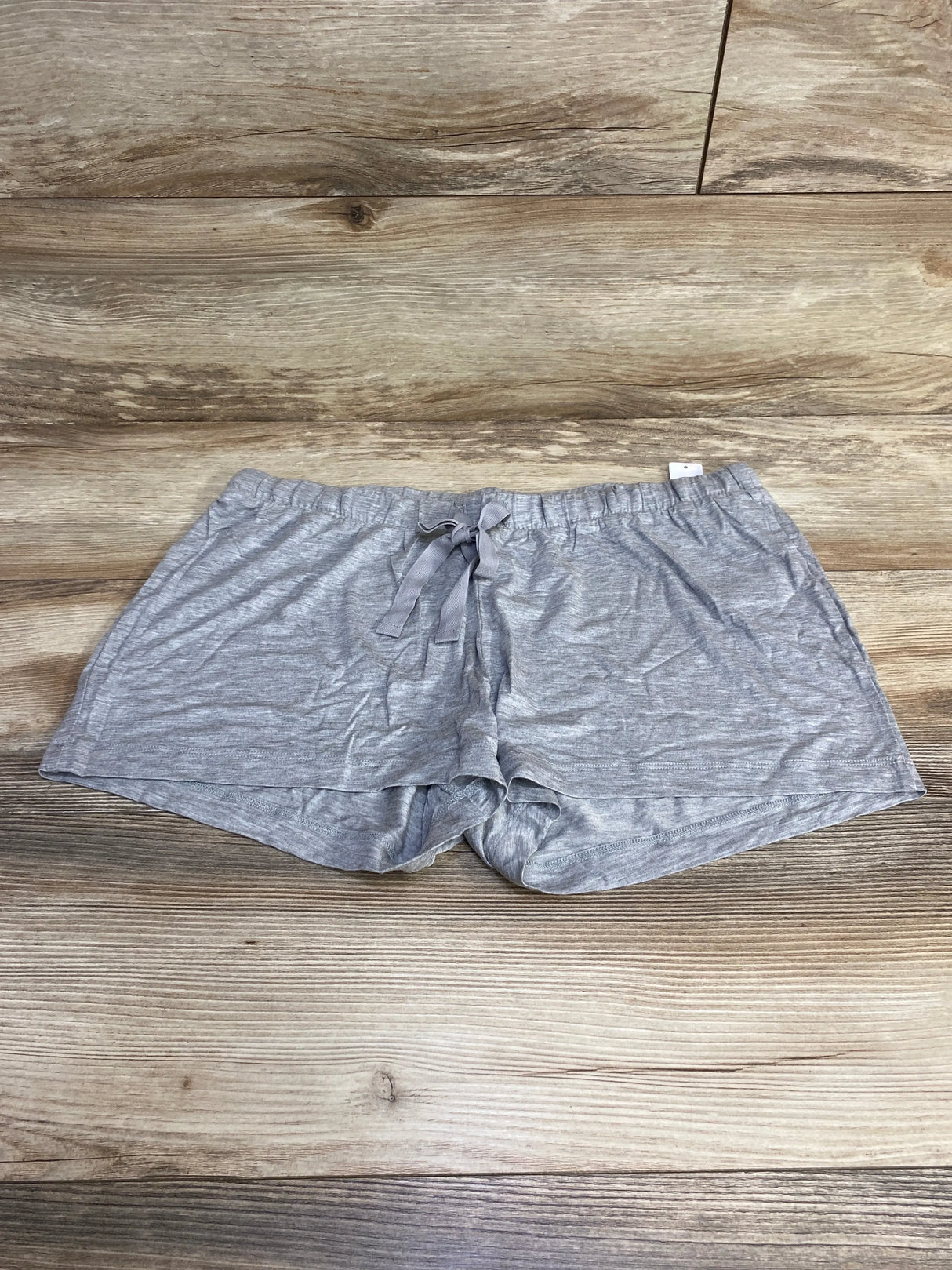 Front view of grey Gap Body maternity modal shorts with elastic drawstring waistband laid flat on wood background