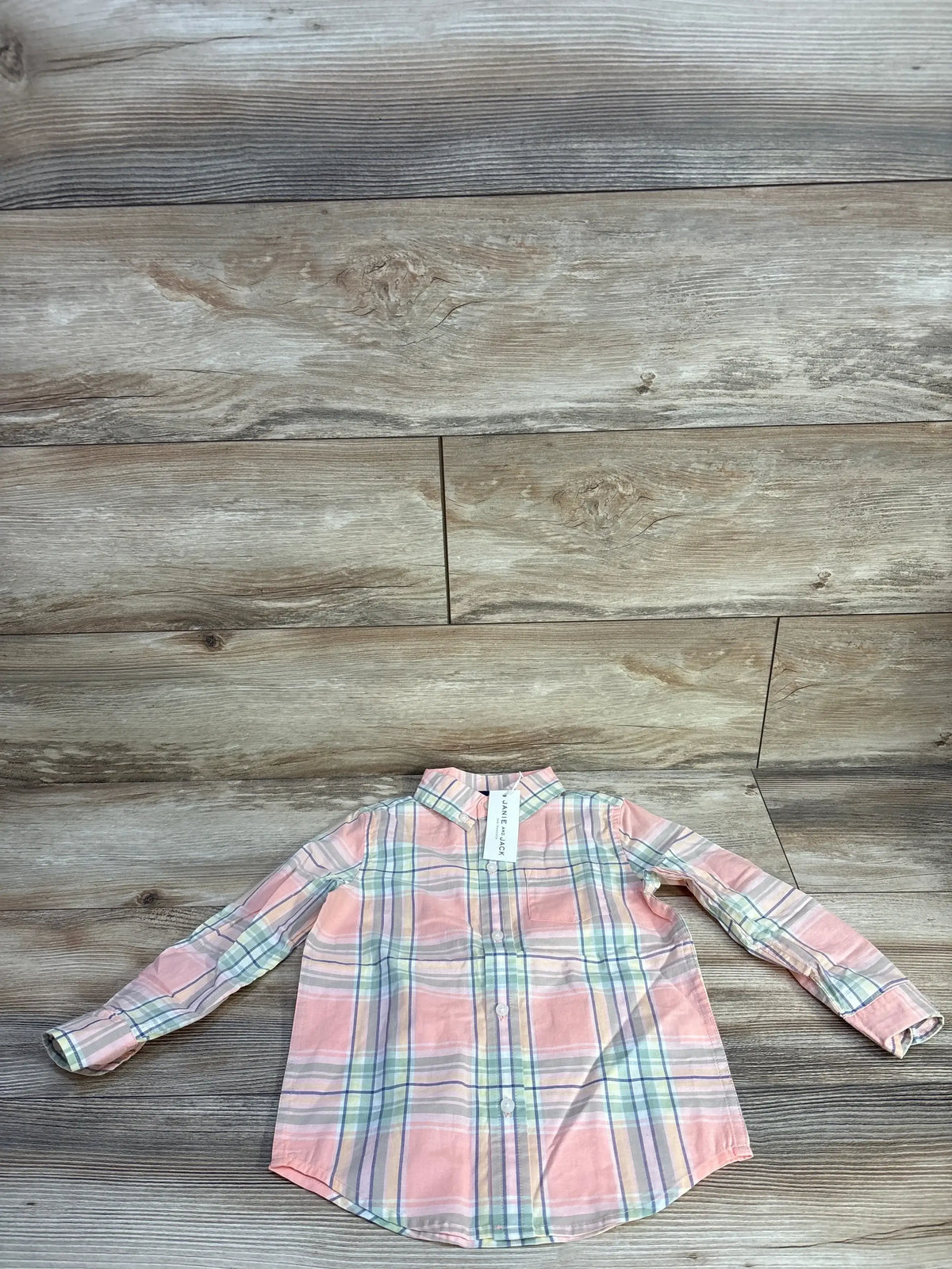 Flat lay of toddler pink plaid button-down shirt (3T) showing long sleeves and band collar on light wood background