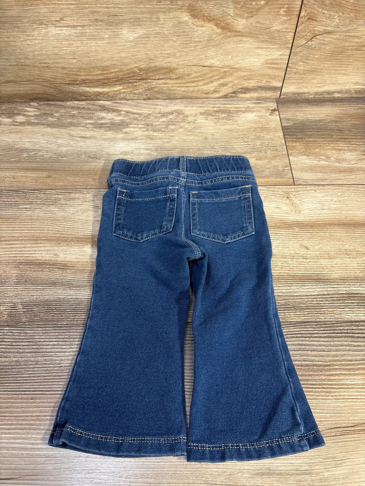 Back view of Cat & Jack blue pull-on flare jeggings for infants on a wooden surface