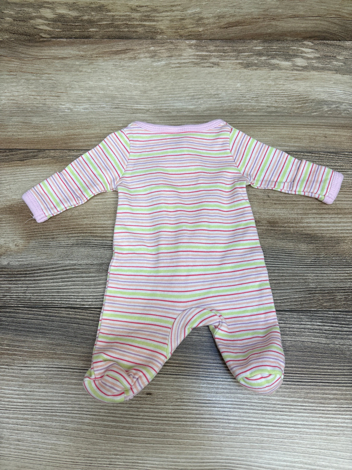 Front view of the Spasilk pink striped sleeper showcasing long sleeves and enclosed feet on a wood-grain background