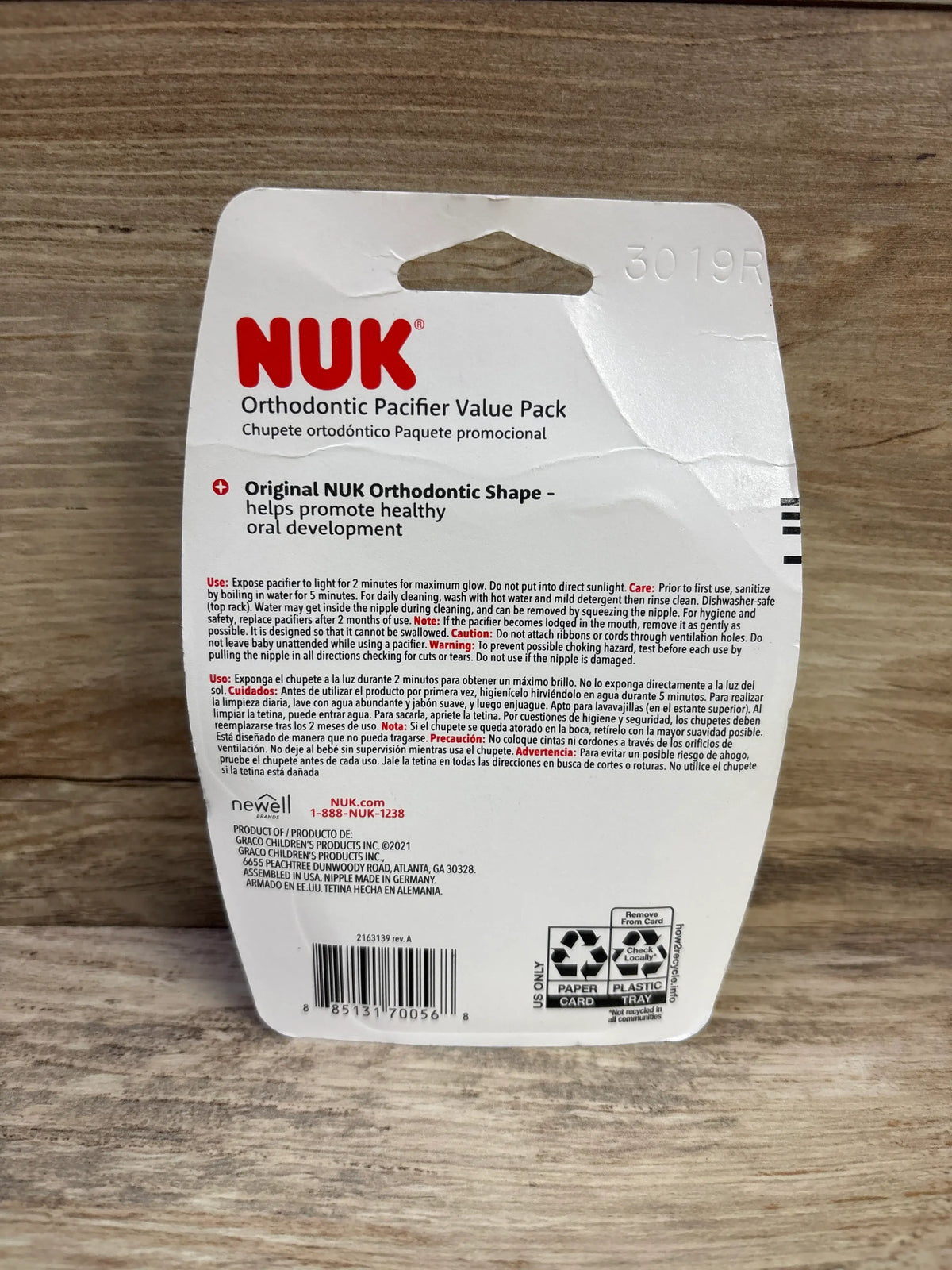 Back view of NUK Orthodontic Pacifier Value Pack packaging showcasing the original orthodontic shape with a wood background