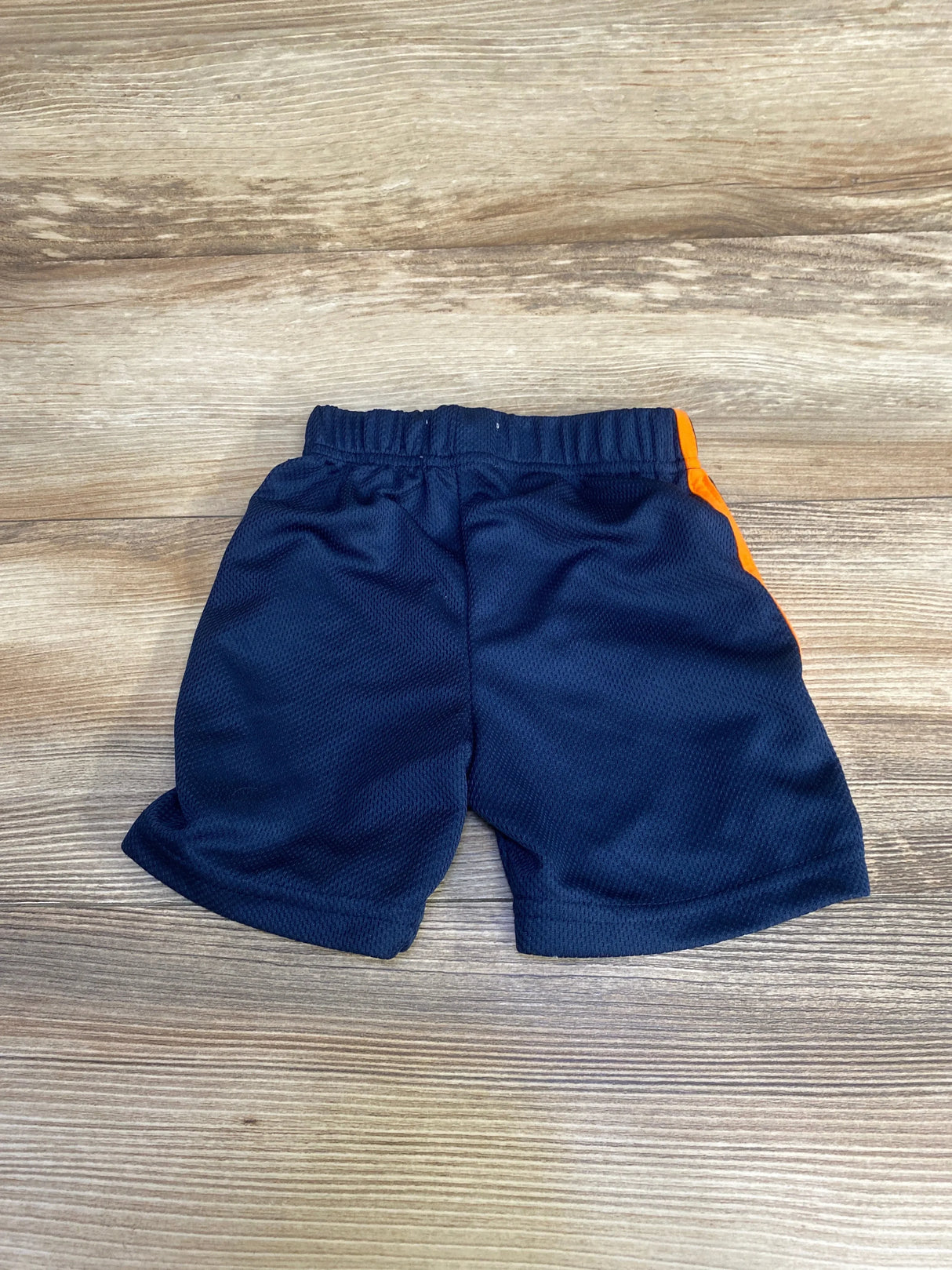 Back view of Alex & Jack navy pull-on toddler shorts (size 12m) showing elastic waistband, mesh fabric and orange side stripe on wood background