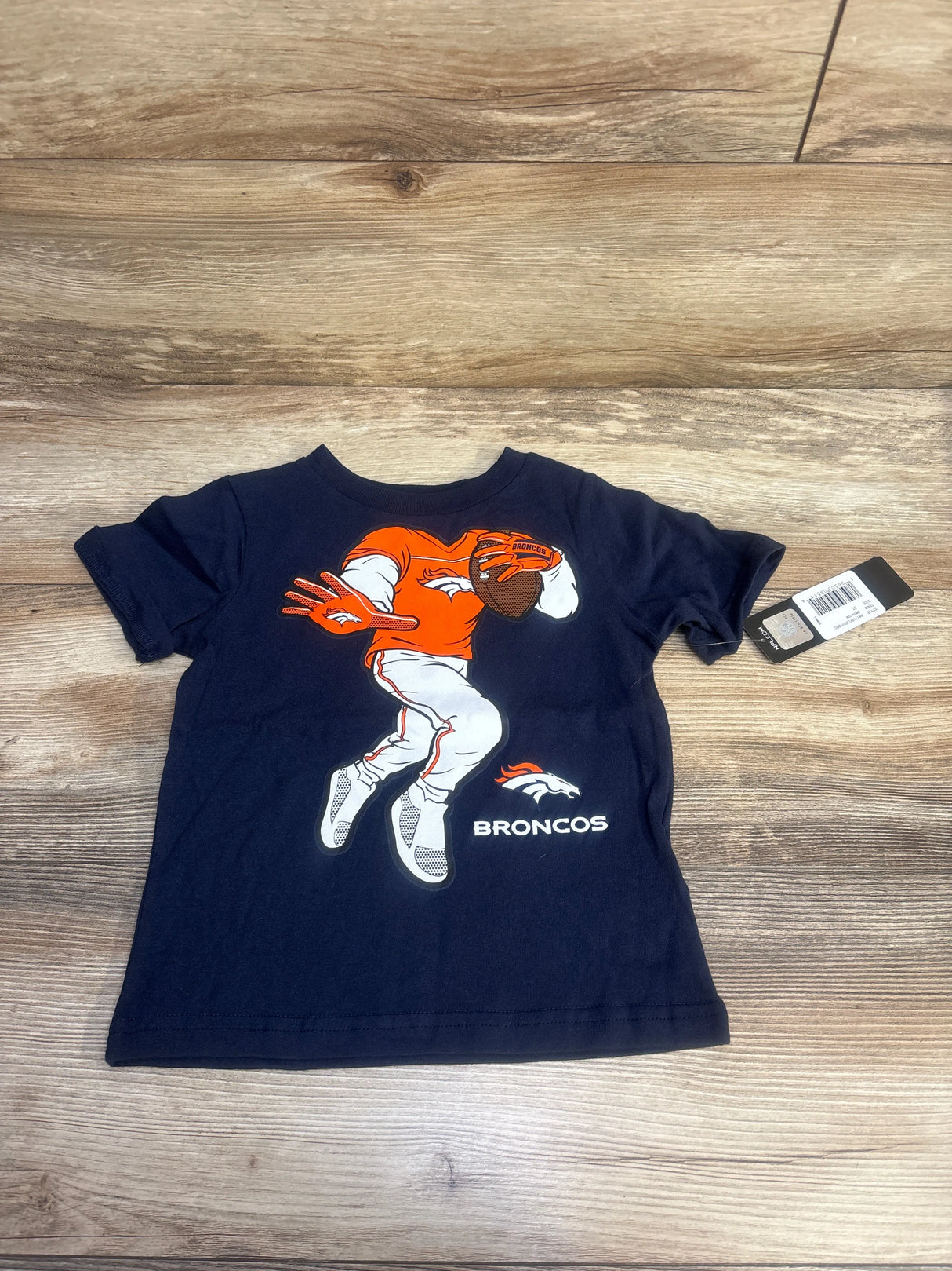 Toddler navy blue Broncos t-shirt with football player graphic and logo on wooden floor