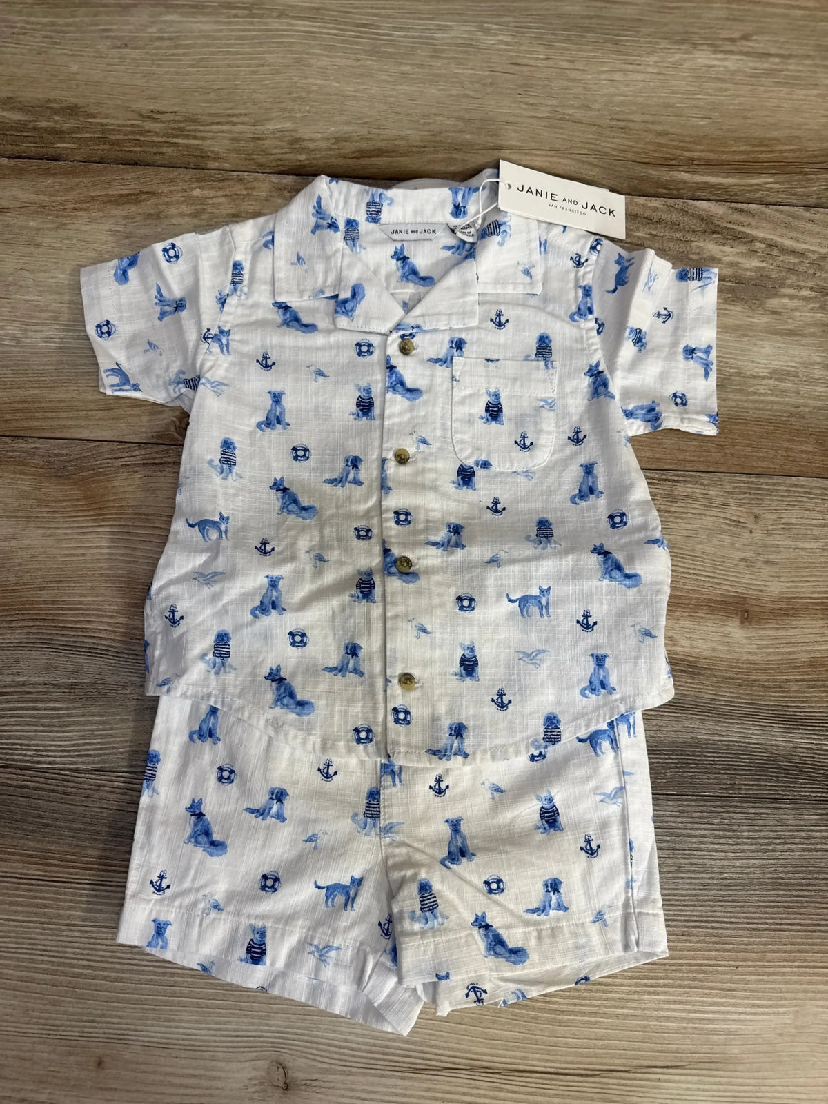 Top view of Janie & Jack 2pc Cabana Set showcasing blue nautical toile, button-front shirt, and chest pocket on wood floor