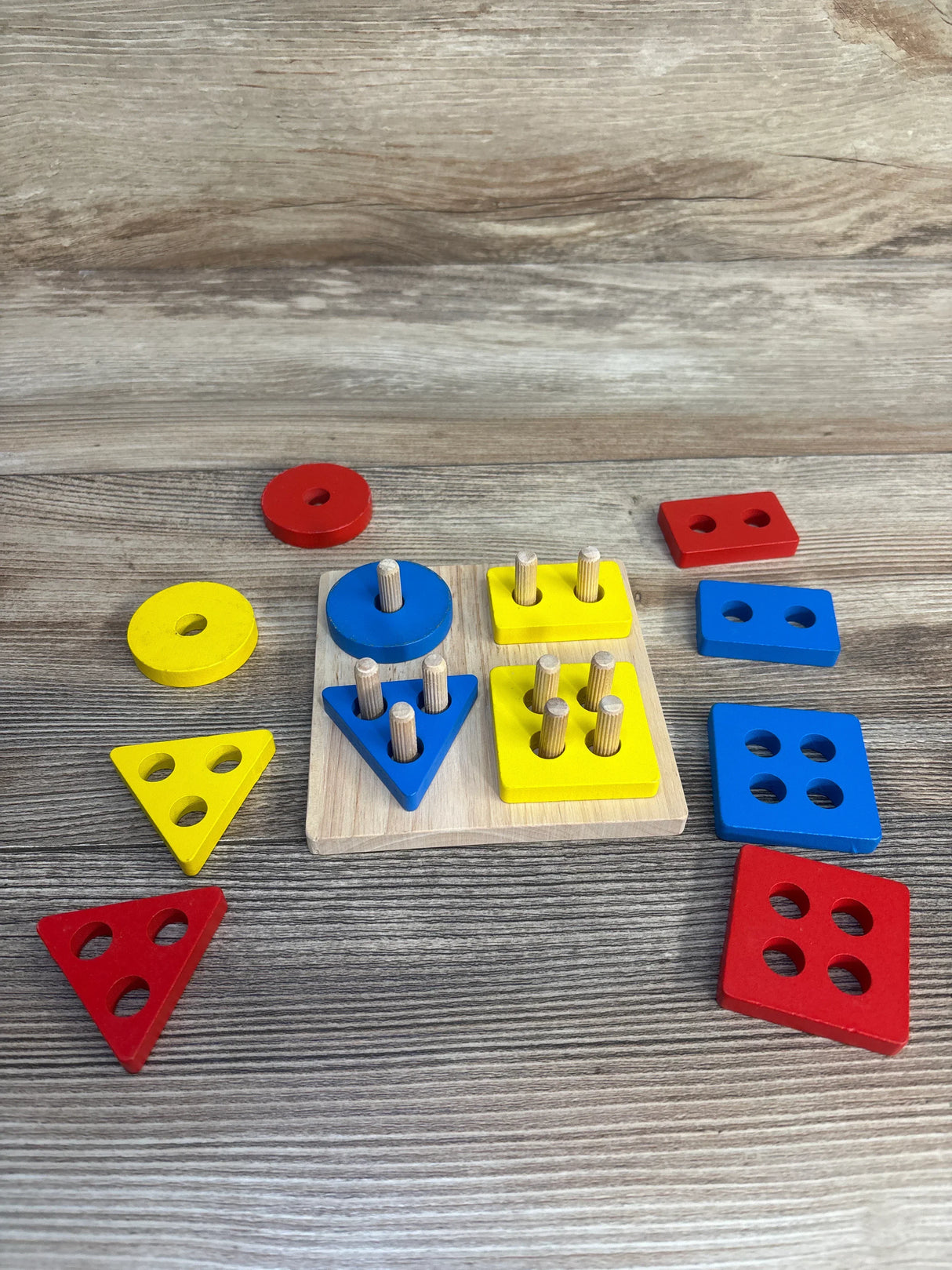 Wooden shape sorting puzzle with colorful geometric blocks for kids on a wooden surface